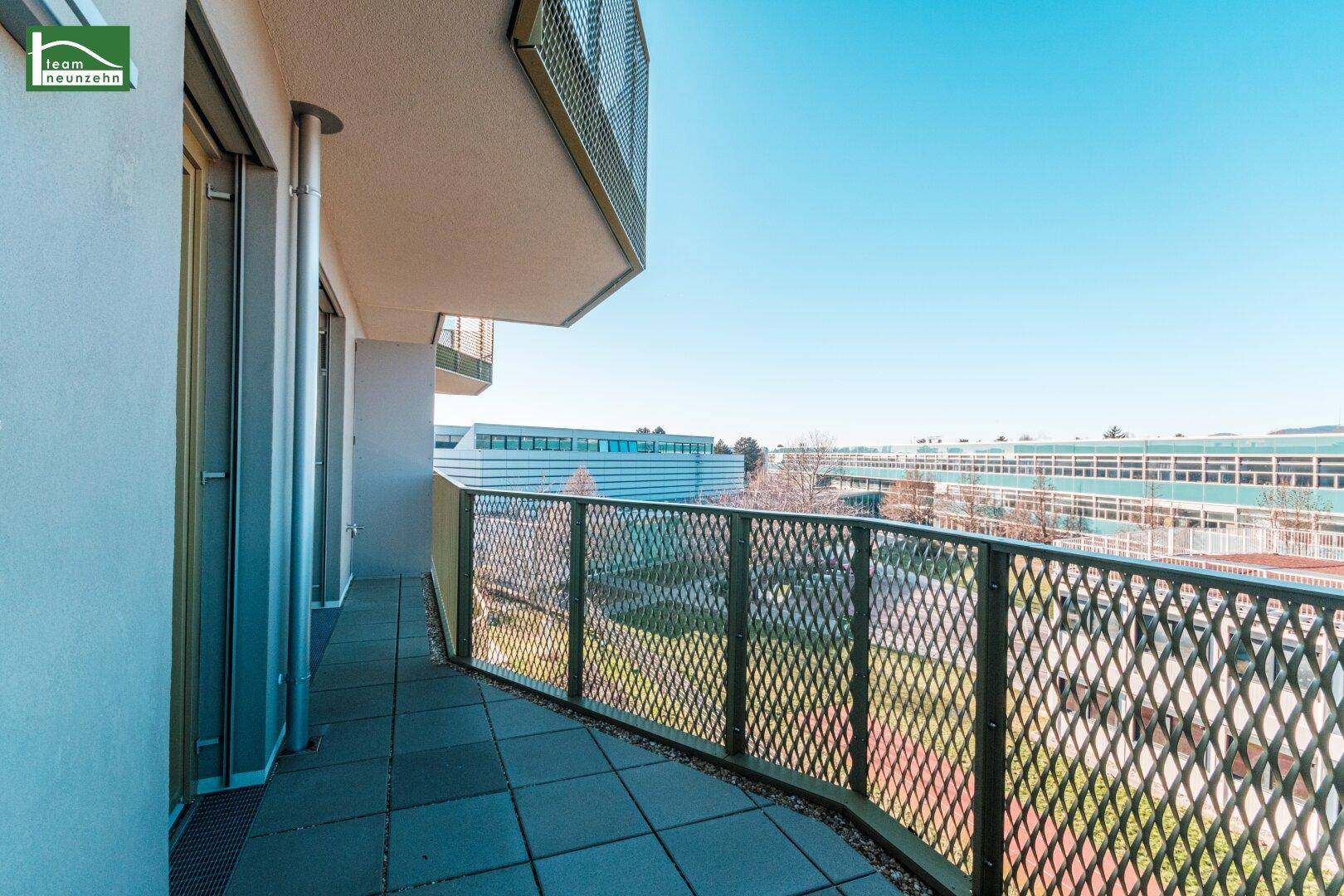 Geräumiger Balkon mit Metallgeländer und Blick auf die Umgebung.