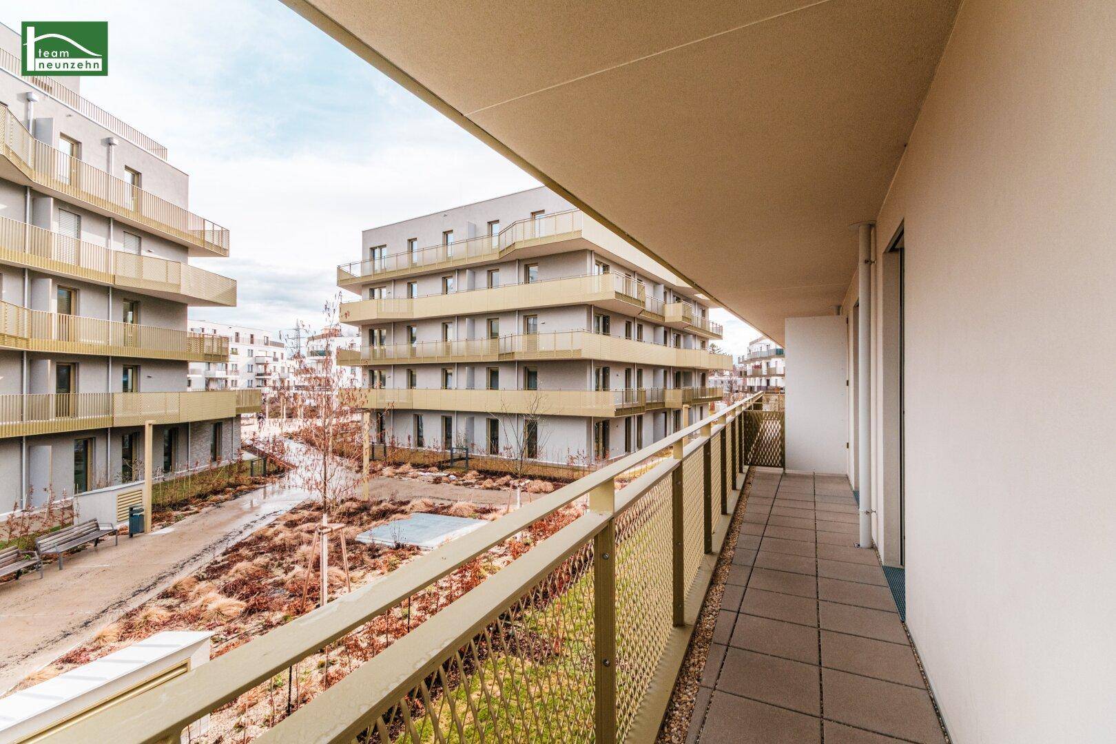Geräumiger Balkon mit Blick auf den Innenhof und die modernen Wohngebäude der Anlage.