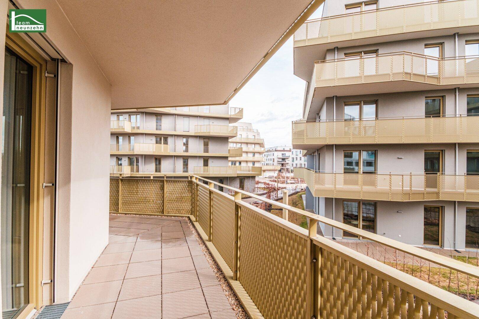 Geräumiger Balkon mit Fliesenboden und Blick auf die umliegenden Gebäude.