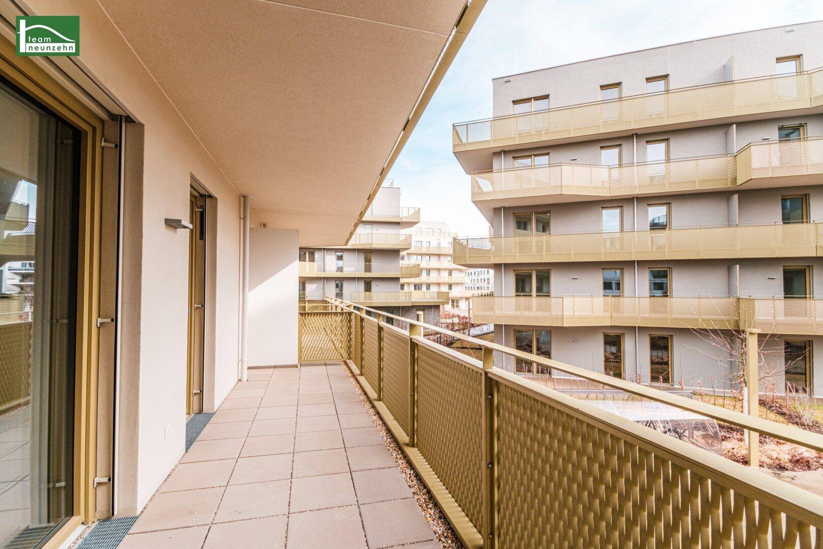 Geräumiger Balkon mit Fliesenboden und Blick auf die umliegenden Gebäude.