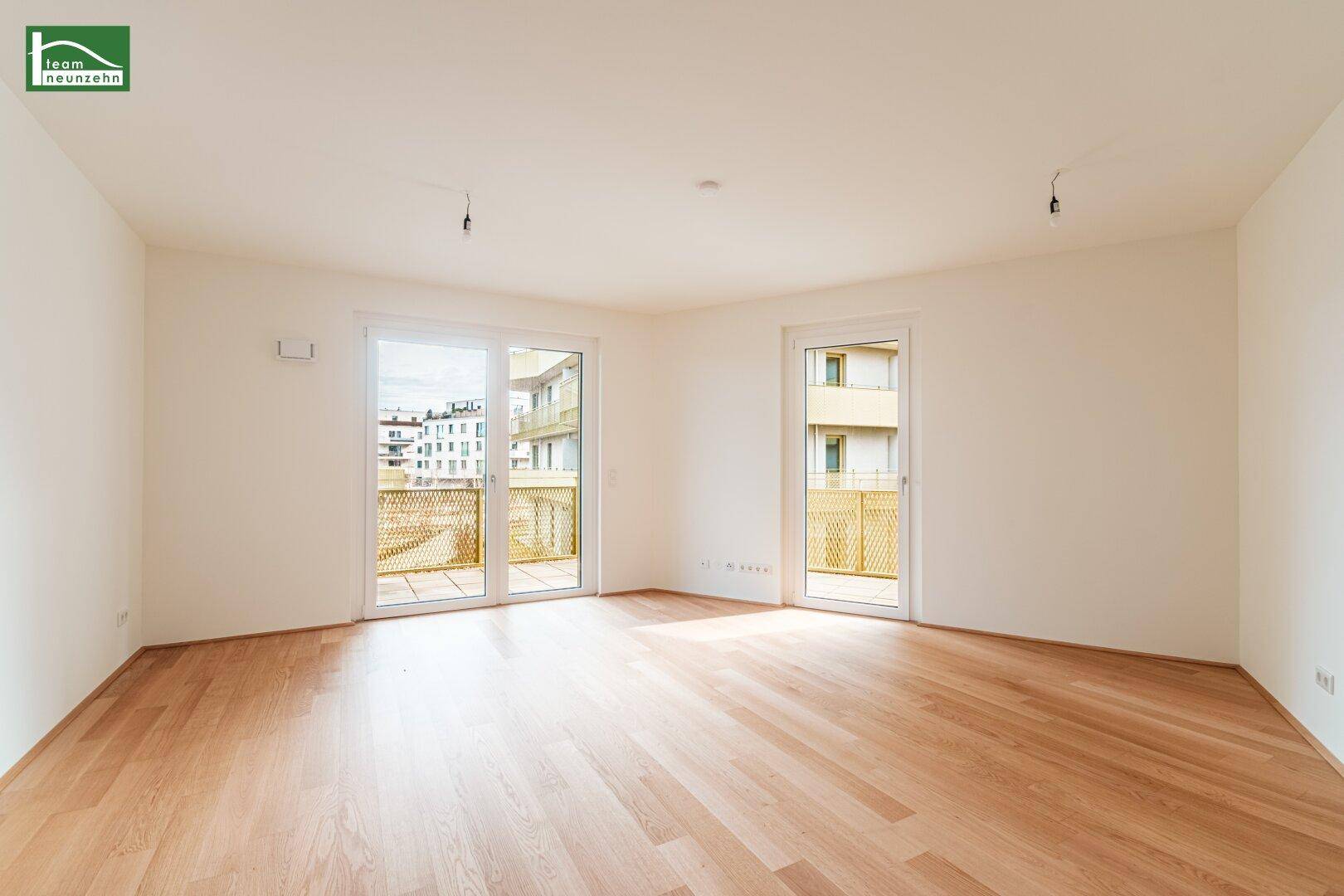 Helles, leeres Zimmer mit Parkettboden und Zugang zu einem Balkon, ideal für Wohn- oder Schlafbereich.