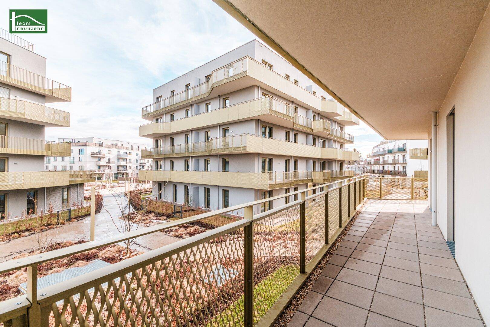 Langer Balkon mit Fliesenboden und Metallgeländer, bietet Blick auf die Umgebung.