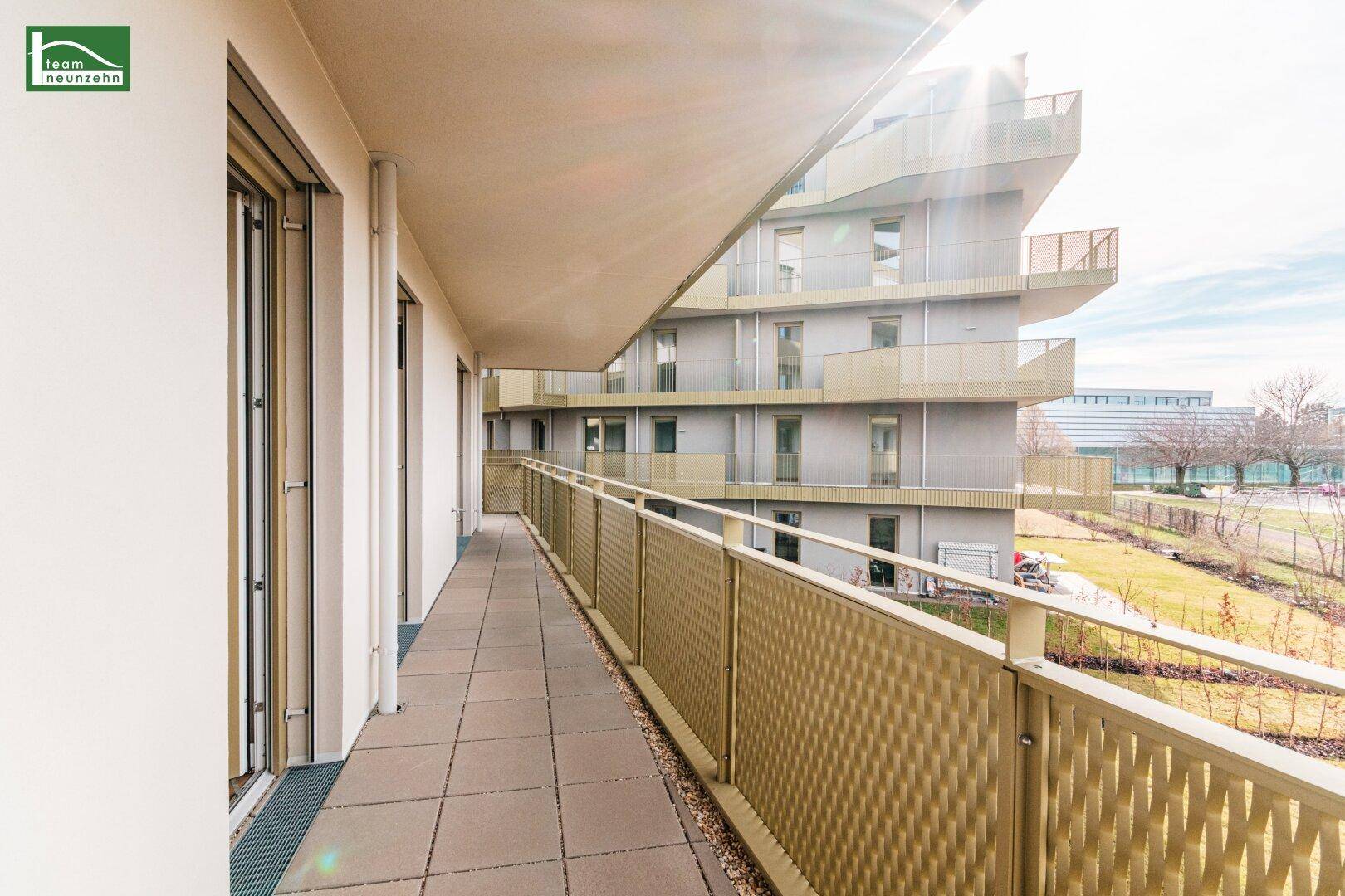 Langer Balkon mit Fliesenboden und Metallgeländer, bietet Blick auf die Umgebung.