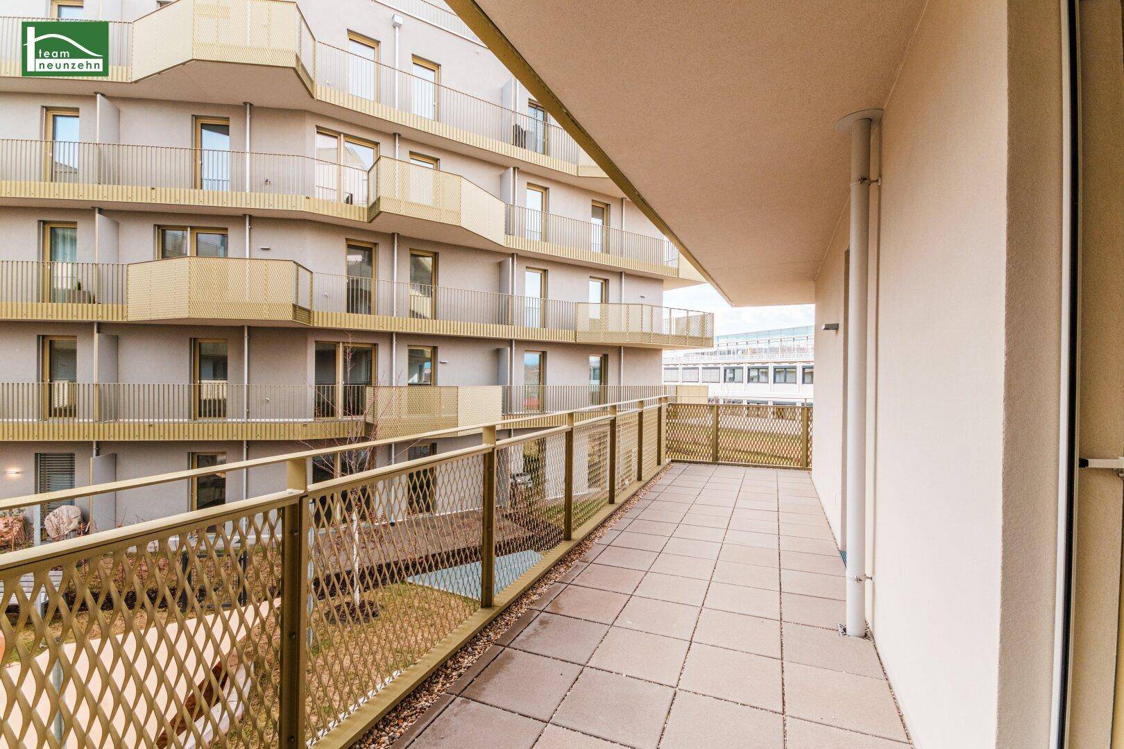Heller Balkon mit Fliesen und Blick auf die moderne Architektur des Wohnkomplexes.