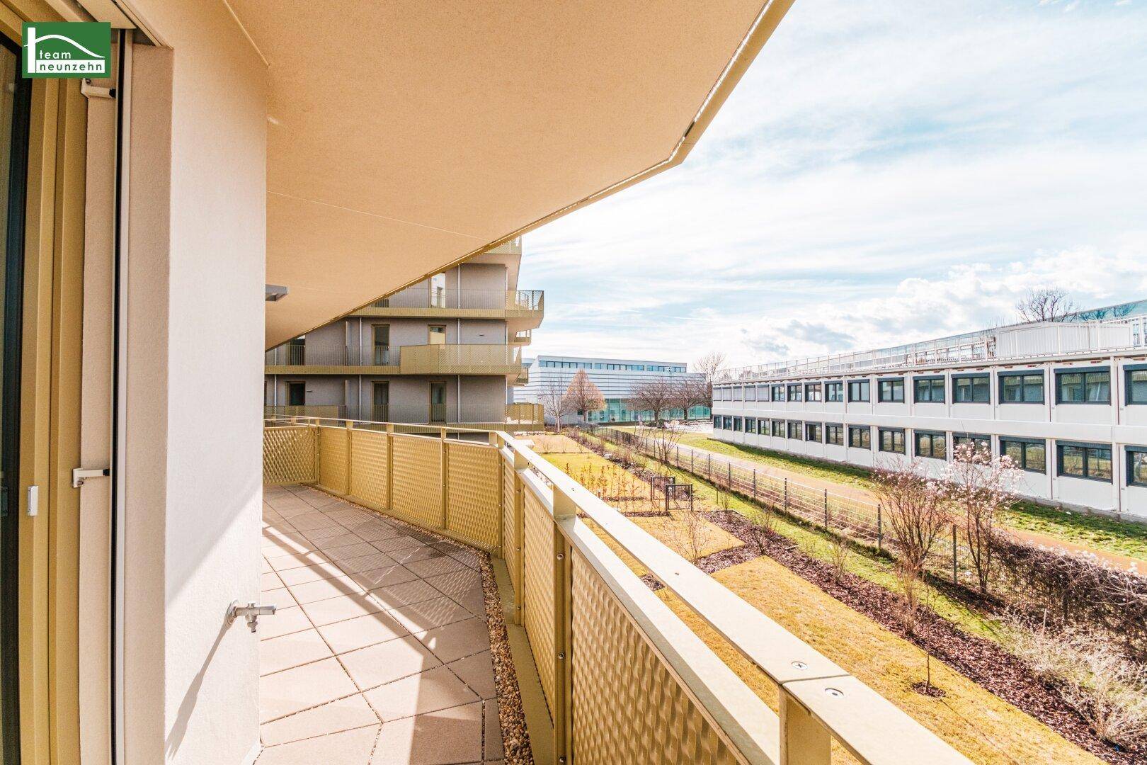 Langer Balkon mit Fliesen und modernem Geländer, ideal zum Entspannen mit Blick ins Grüne.