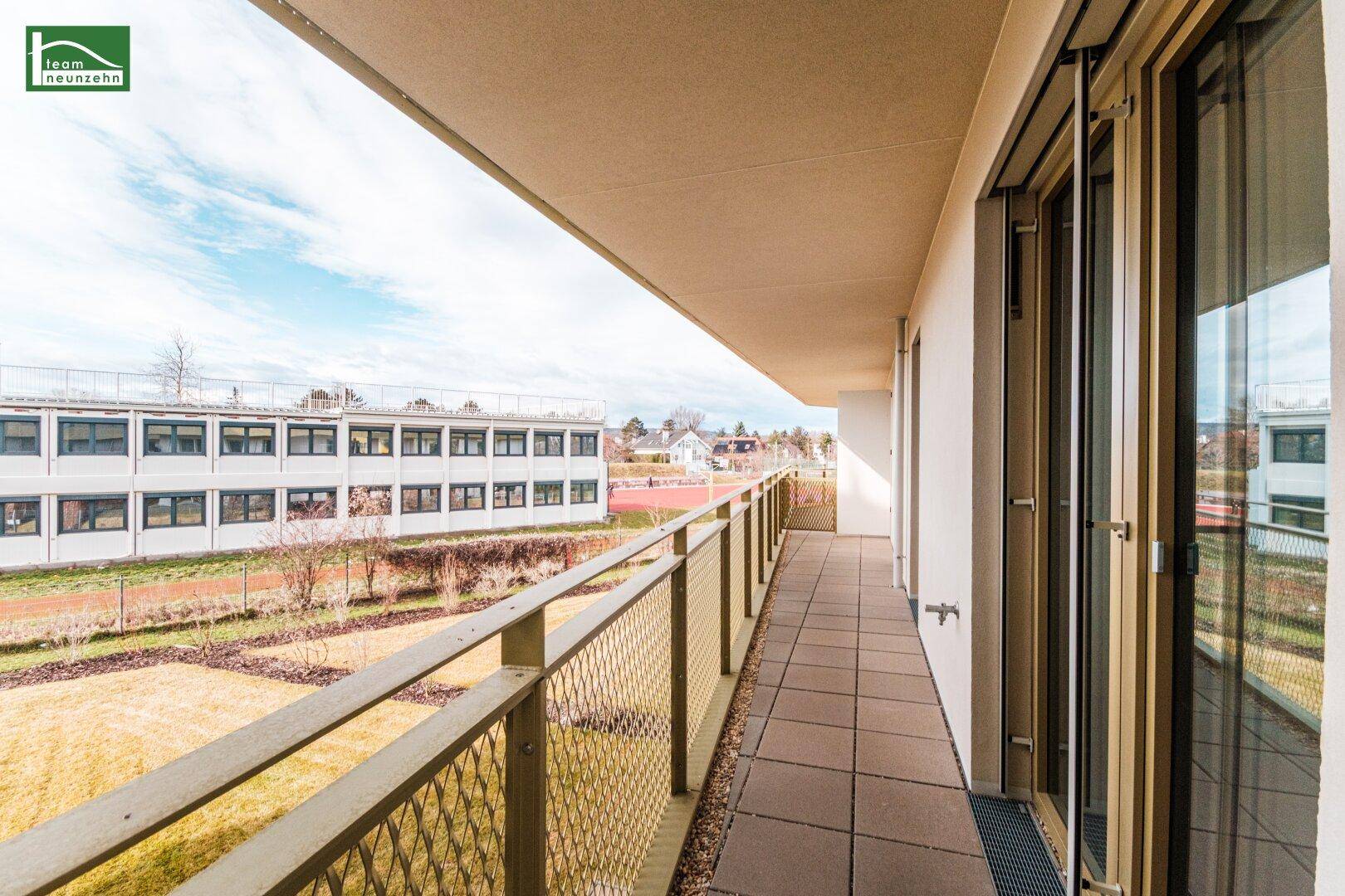 Sonniger Balkon mit Fliesenboden und weitem Blick auf die Umgebung.