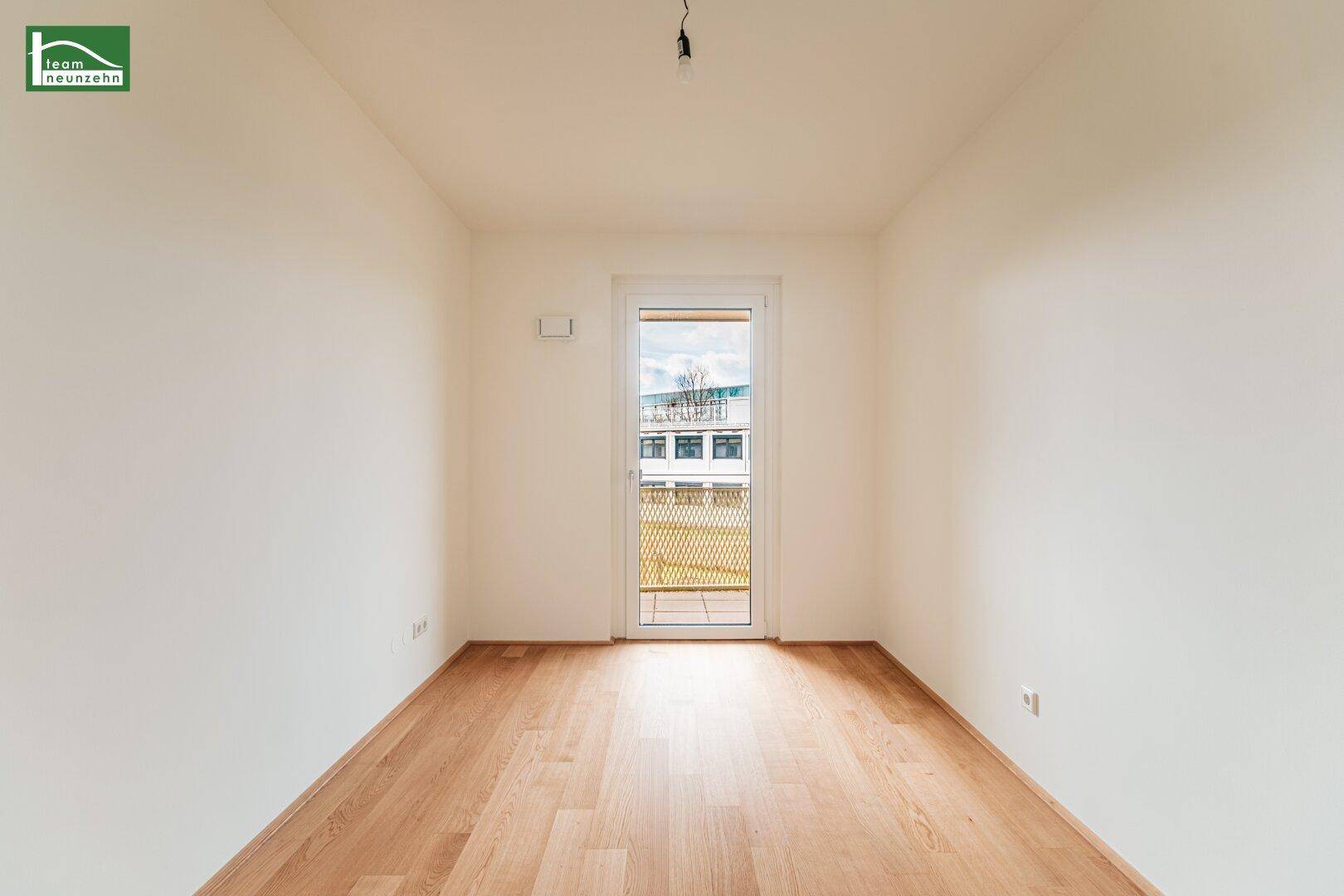 Kleiner, heller Raum mit Parkettboden und Fenster zum Außenbereich.