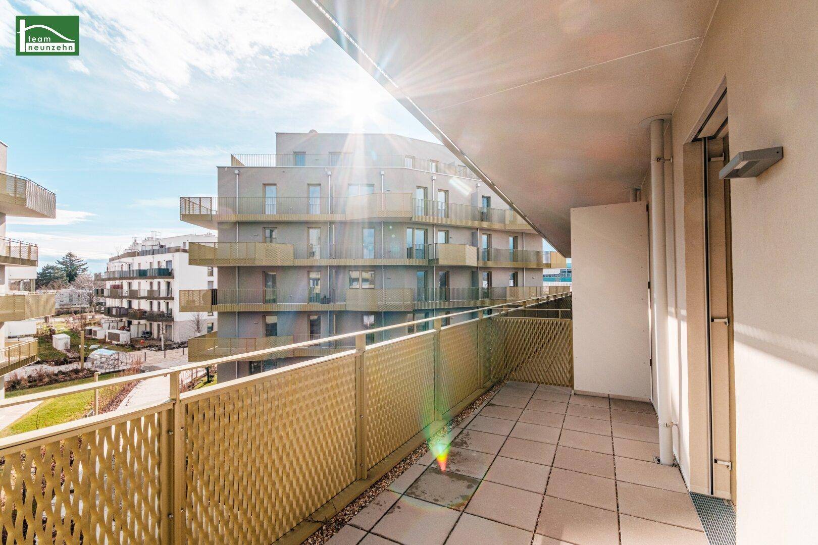 Sonniger Balkon mit Fliesen und Blick auf die umliegenden modernen Gebäude.