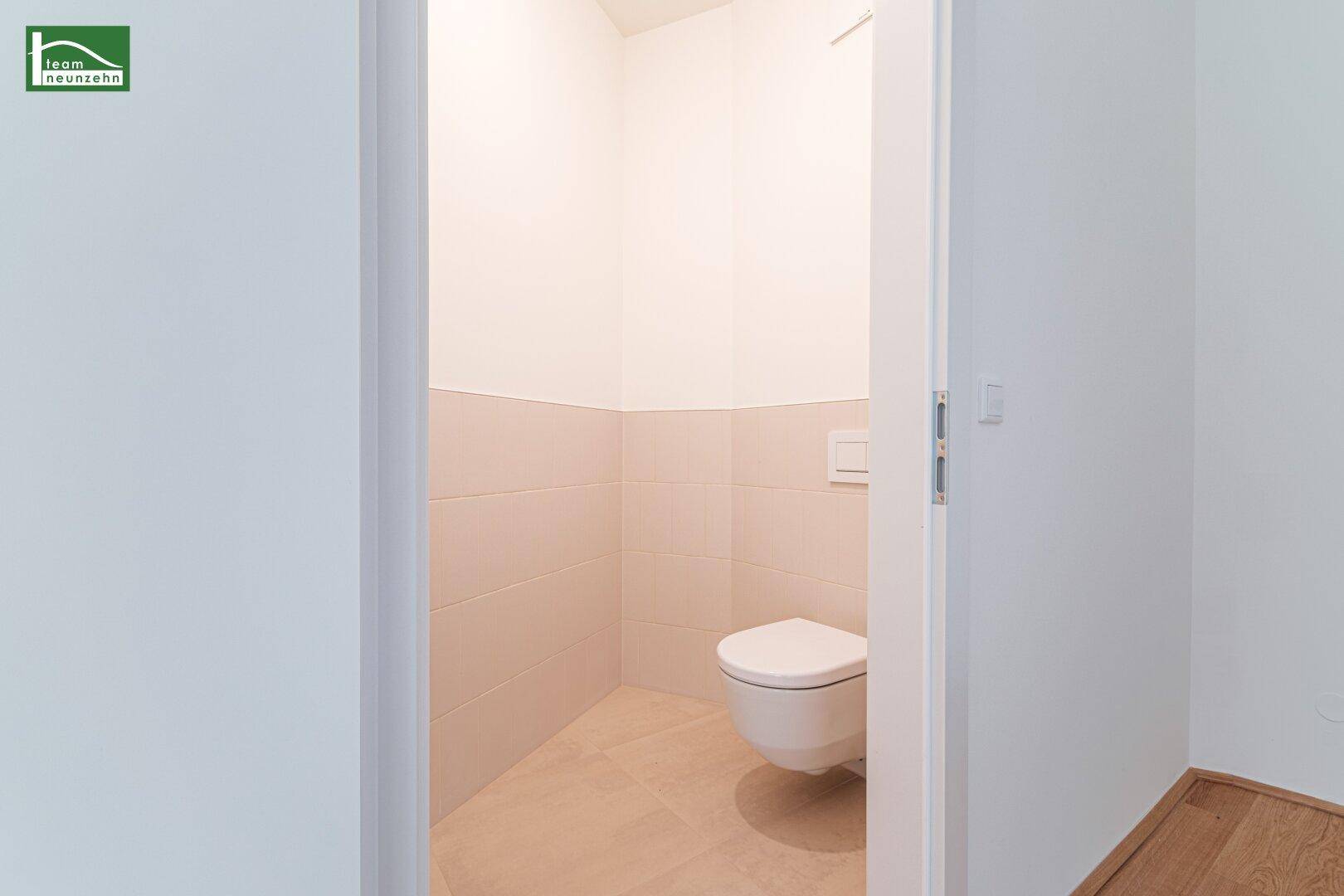 Separates WC mit hellen Fliesen und wandhängendem WC, praktisch und platzsparend.