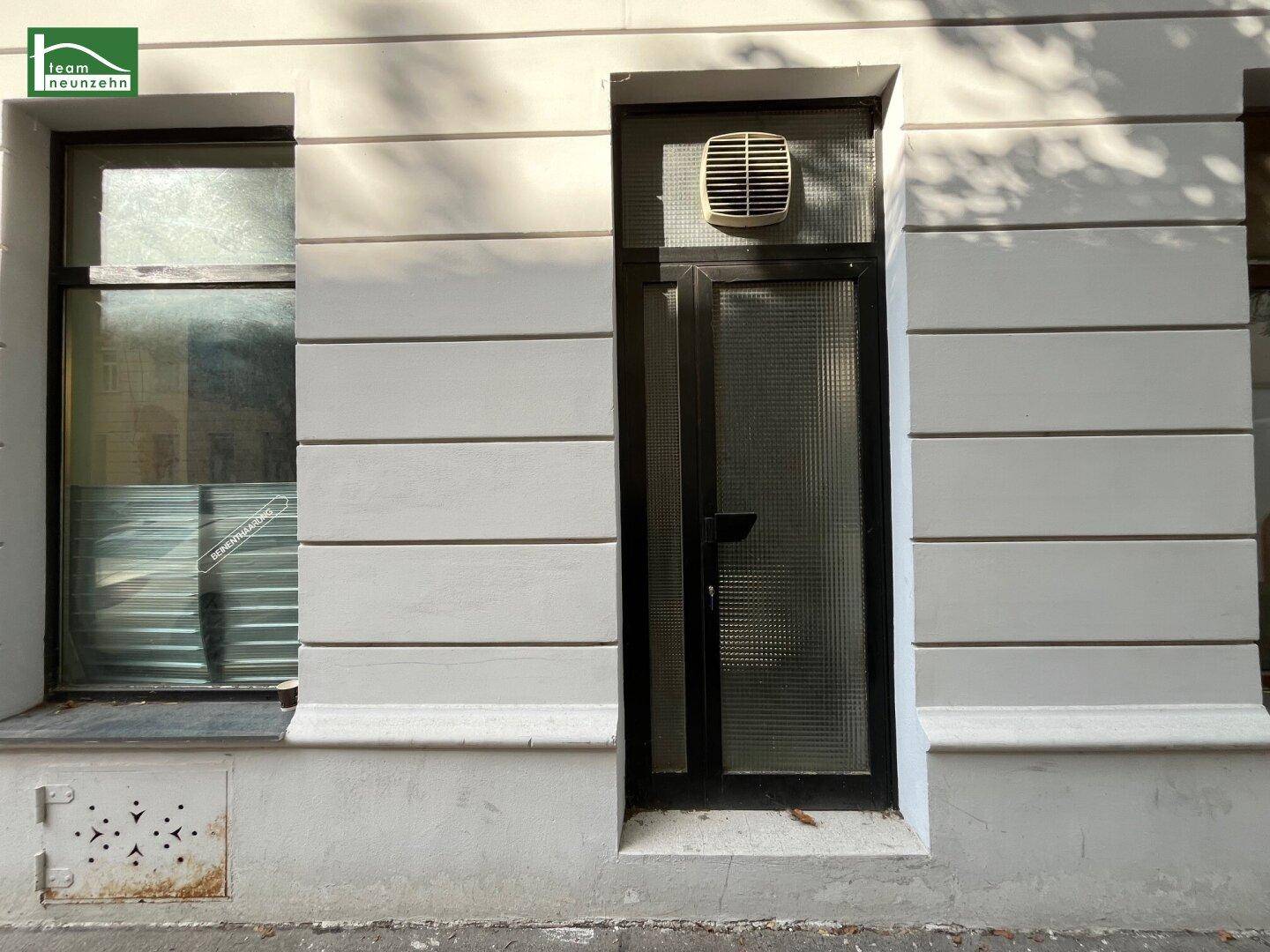 Fassade eines Altbaus mit Eingangstür und Fenster, das Renovierungsbedarf zeigt.
