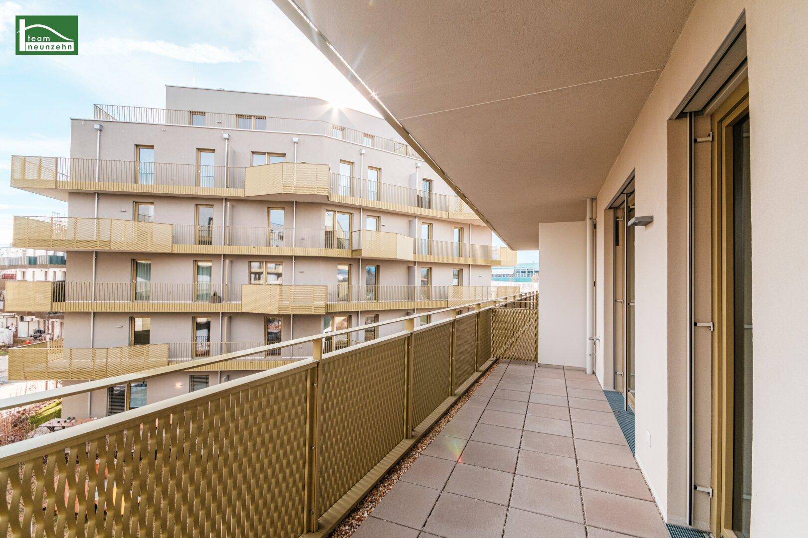 Langer Balkon mit moderner Metallbrüstung und Blick auf die umliegenden Neubauten.