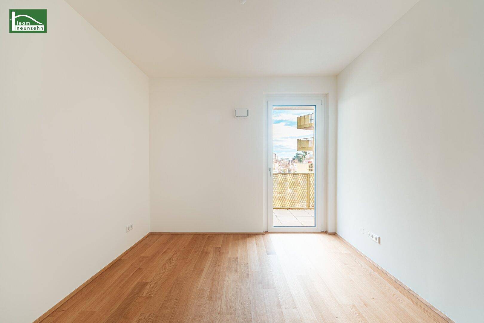 Helles Zimmer mit Holzboden und Zugang zu einem Außenbereich, ideal als Schlafzimmer.