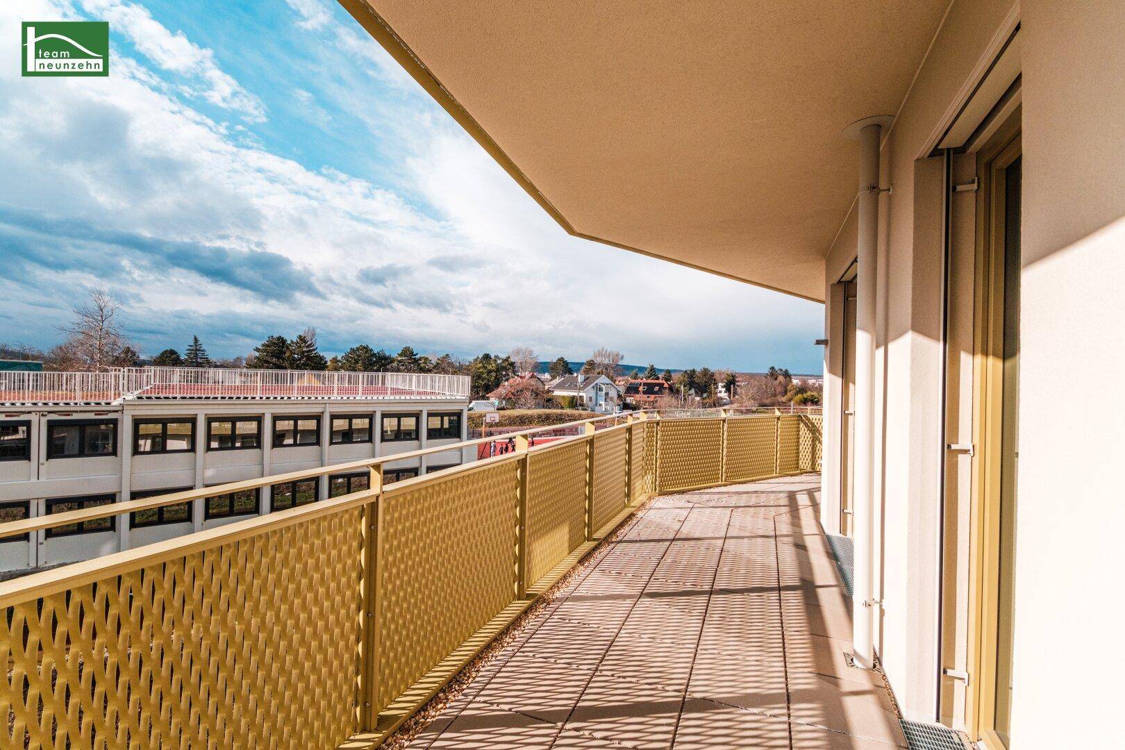 Geräumiger Balkon mit Fliesenboden und gelbem Geländer, bietet Weitblick.