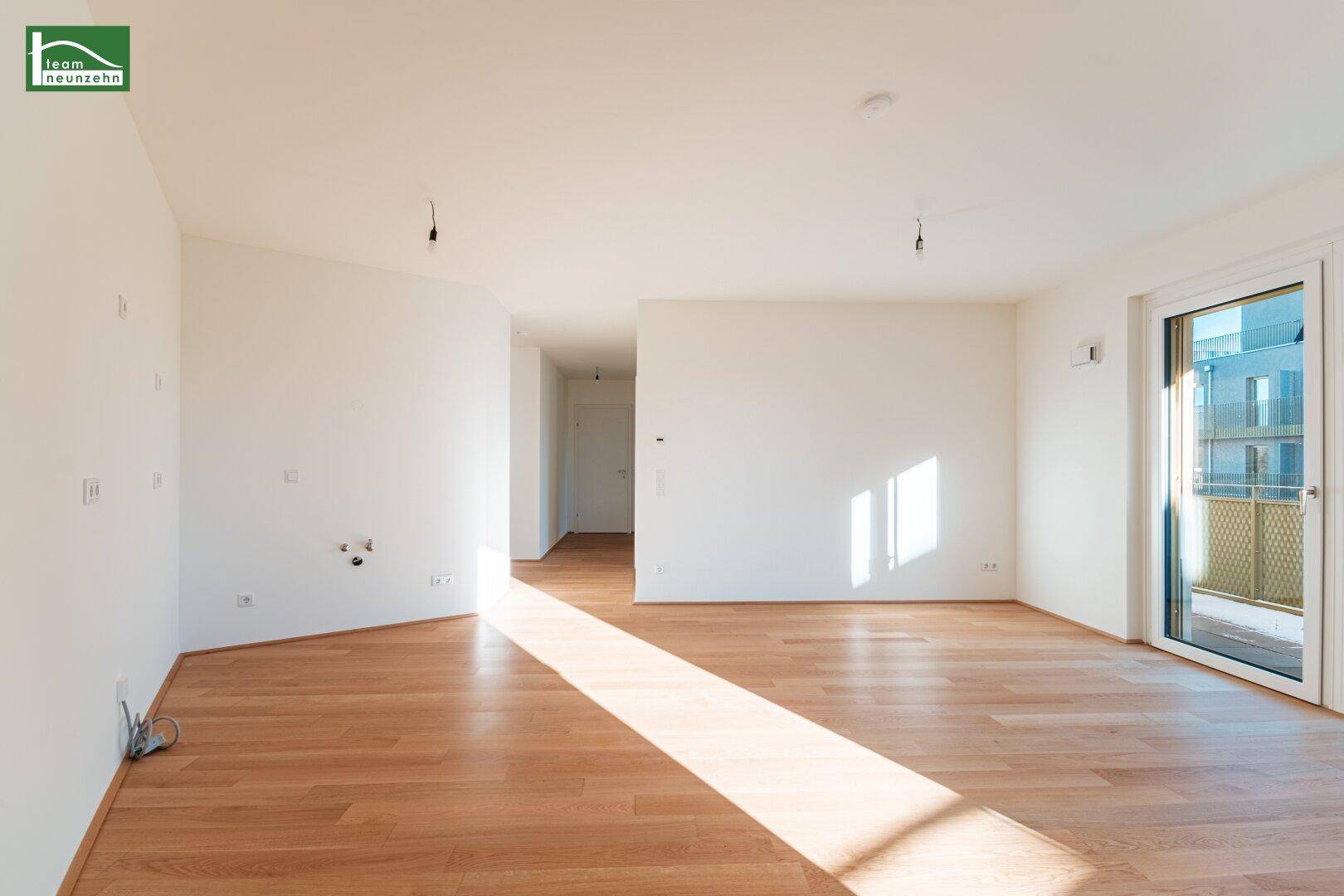 Geräumiges, leeres Zimmer mit Holzboden und viel Tageslicht, bereit zum Einzug.
