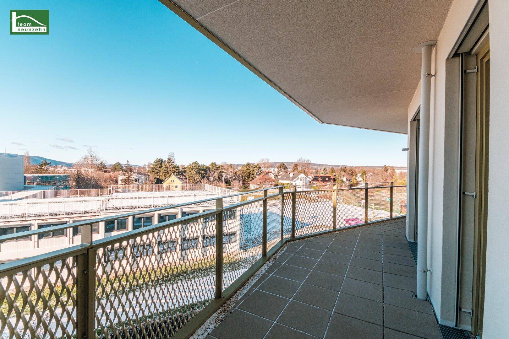 Langer Balkon mit Fliesenboden und Metallgeländer, ideal für Entspannung im Freien.