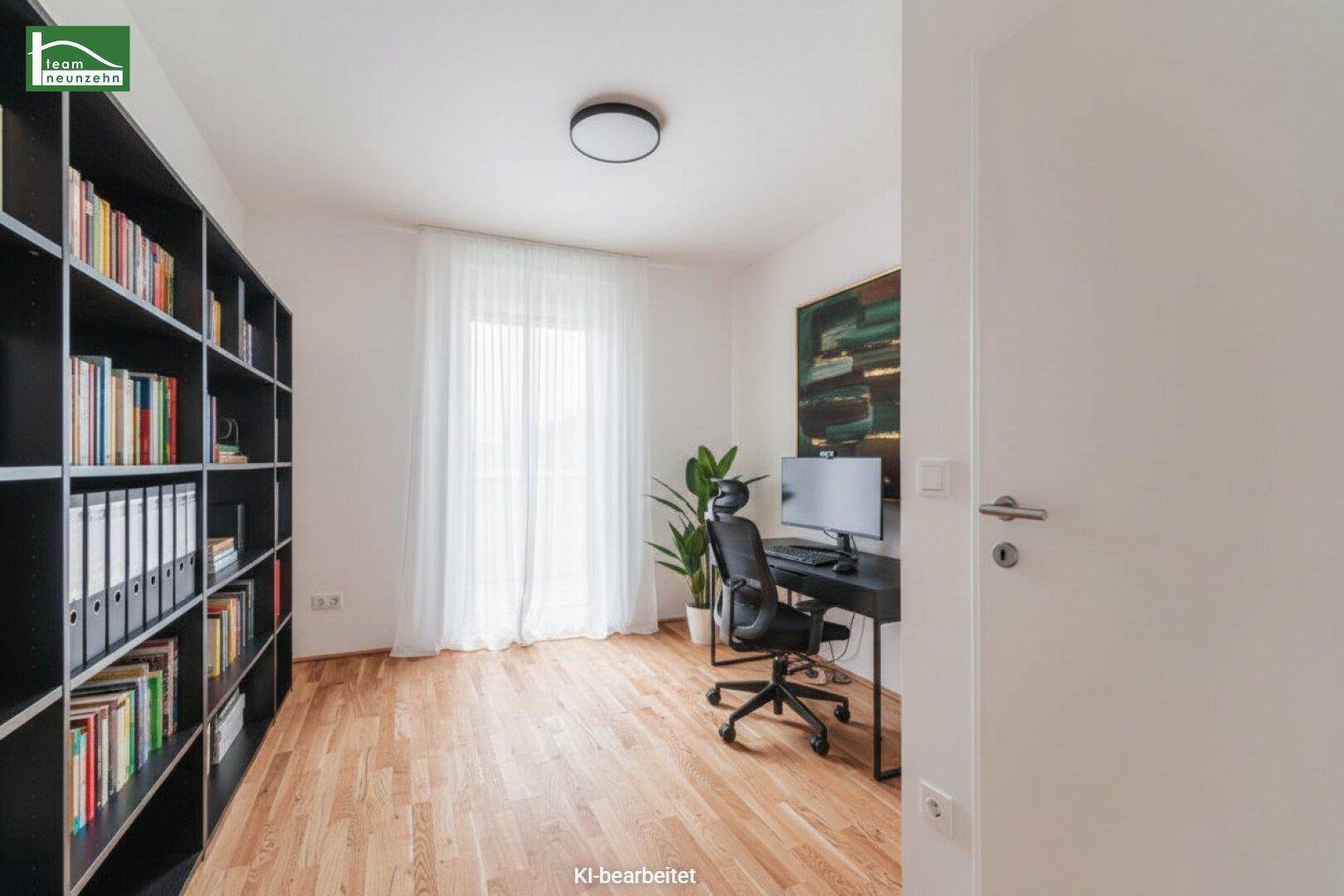 Helles Arbeitszimmer mit großem Bücherregal, Schreibtisch und Parkettboden.
