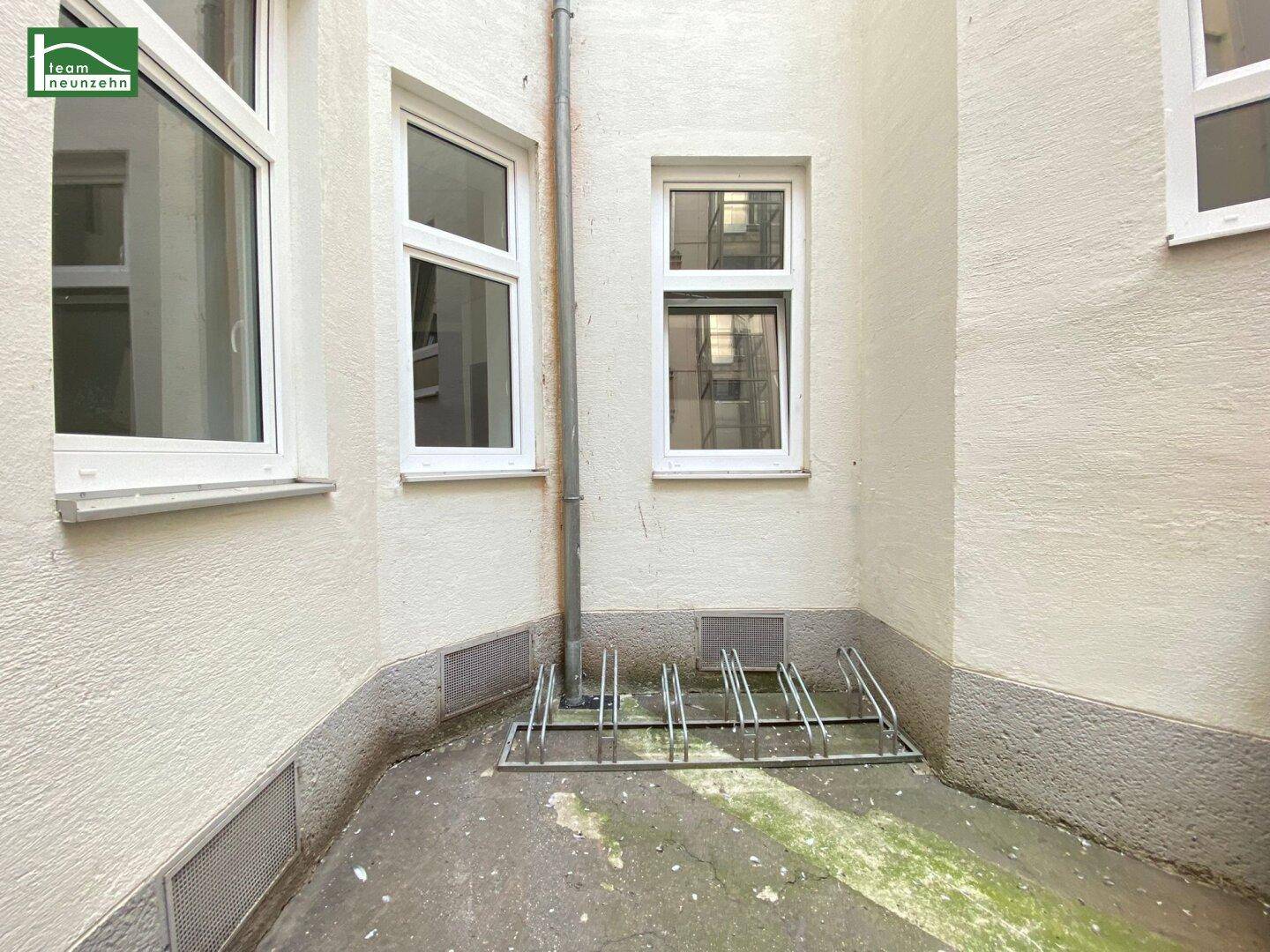 Innenhof mit Fahrradständern und Fenstern der umliegenden Gebäude.