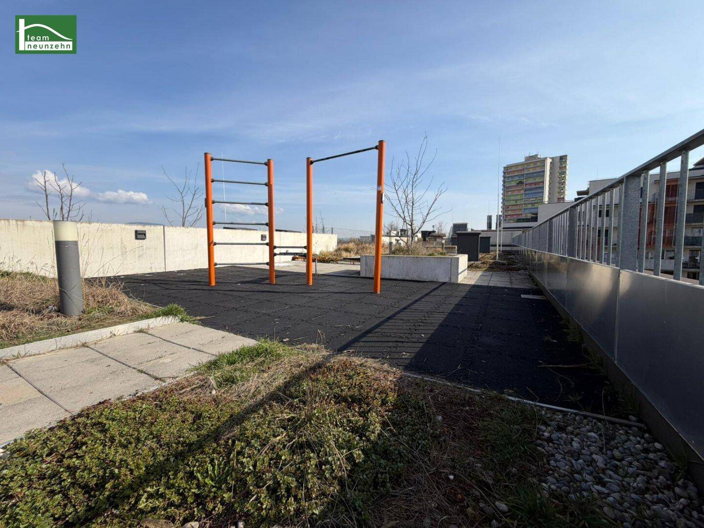 Dachterrasse mit Outdoor-Fitnessgeräten und Blick auf die Umgebung.