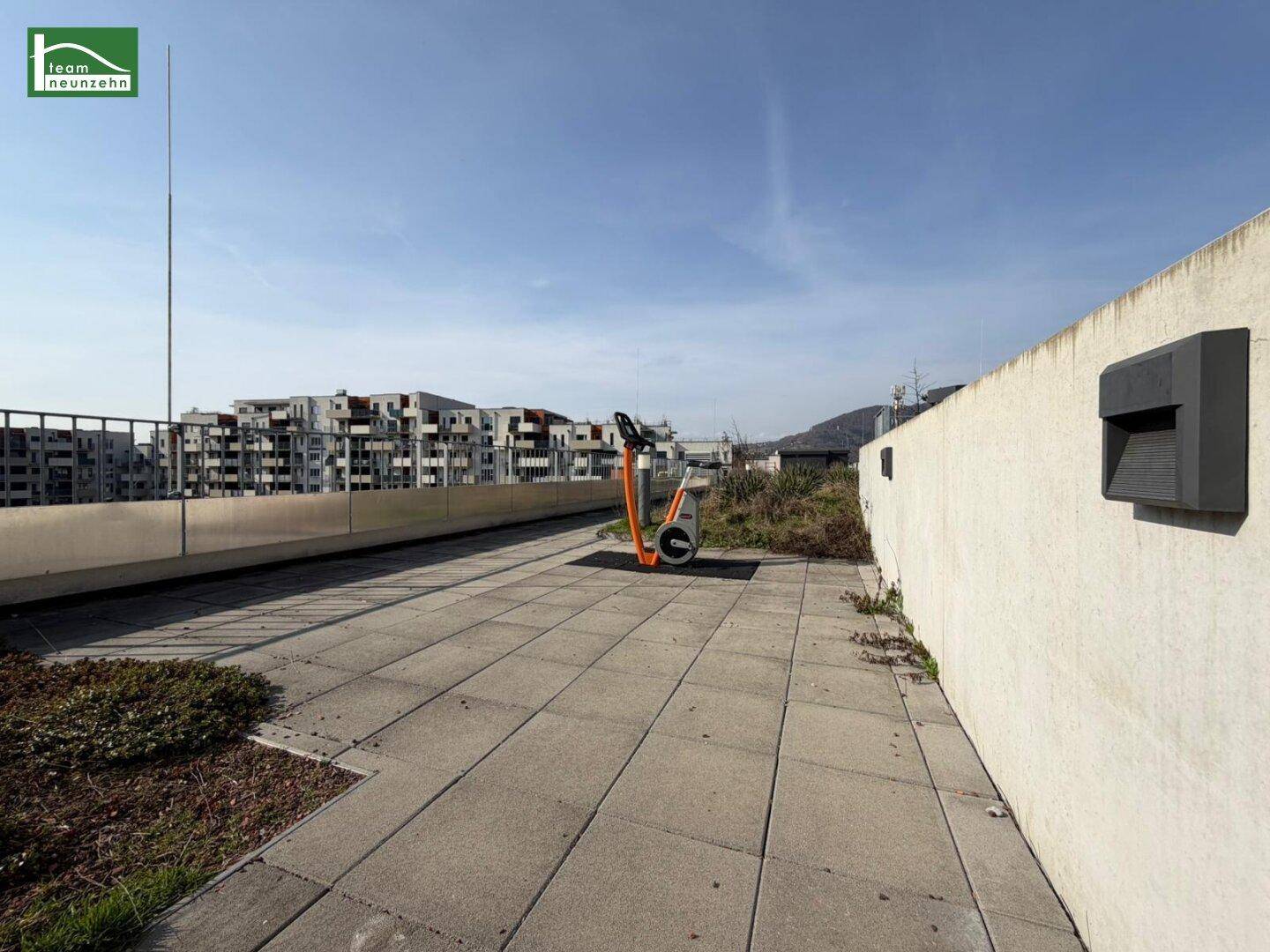 Geräumige Dachterrasse mit Steinplatten und weitem Blick über die Wohngegend.