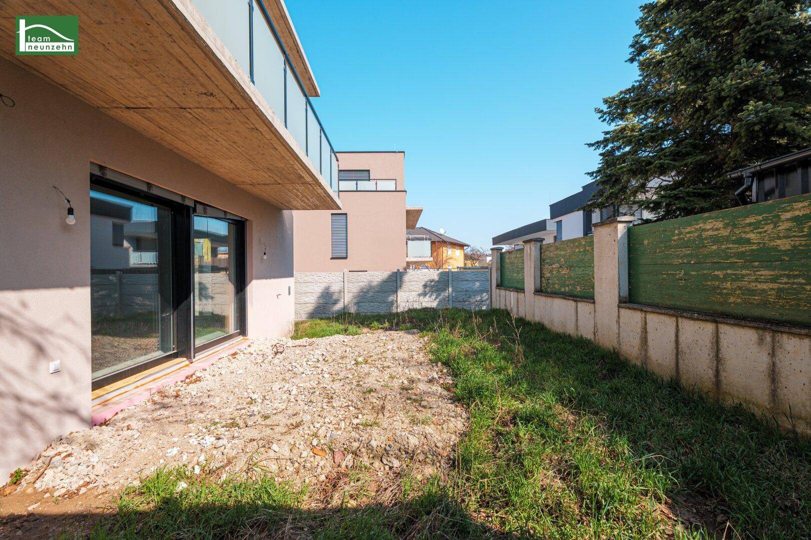 Kleiner Gartenbereich neben dem Haus mit Schiebetüren zum Innenraum.