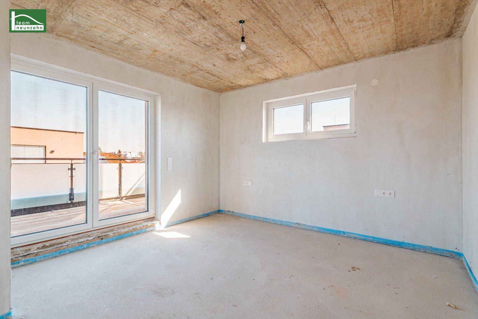 Heller, unfertiger Raum mit Fenster und Balkonzugang, ideal für ein Schlafzimmer.