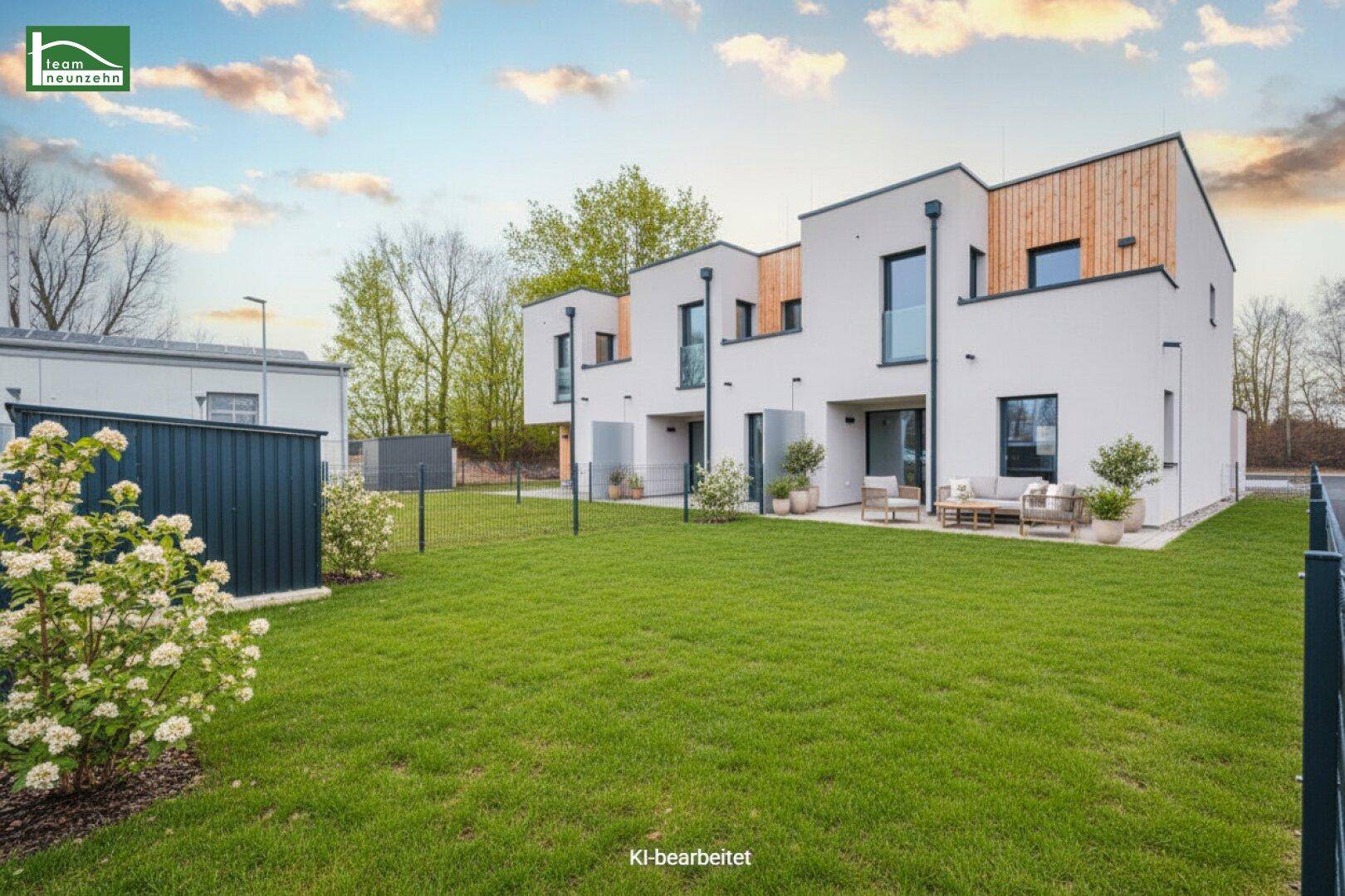 Moderne Reihenhäuser mit gepflegtem Rasen, kleinen Terrassen und Holzverkleidung an der Fassade.