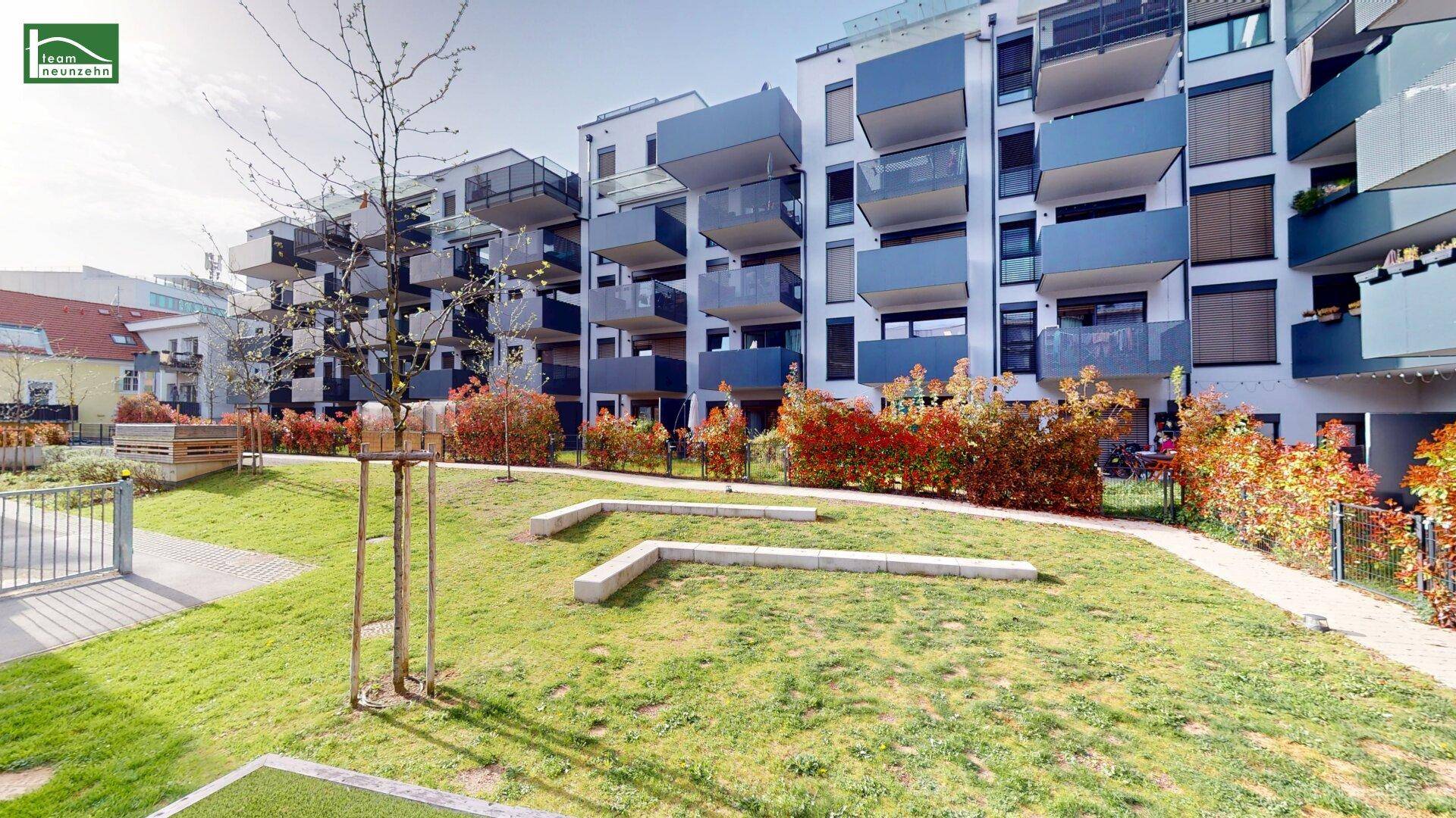 Moderne Wohnanlage mit zahlreichen Balkonen und einem gepflegten Gartenbereich im Vordergrund.