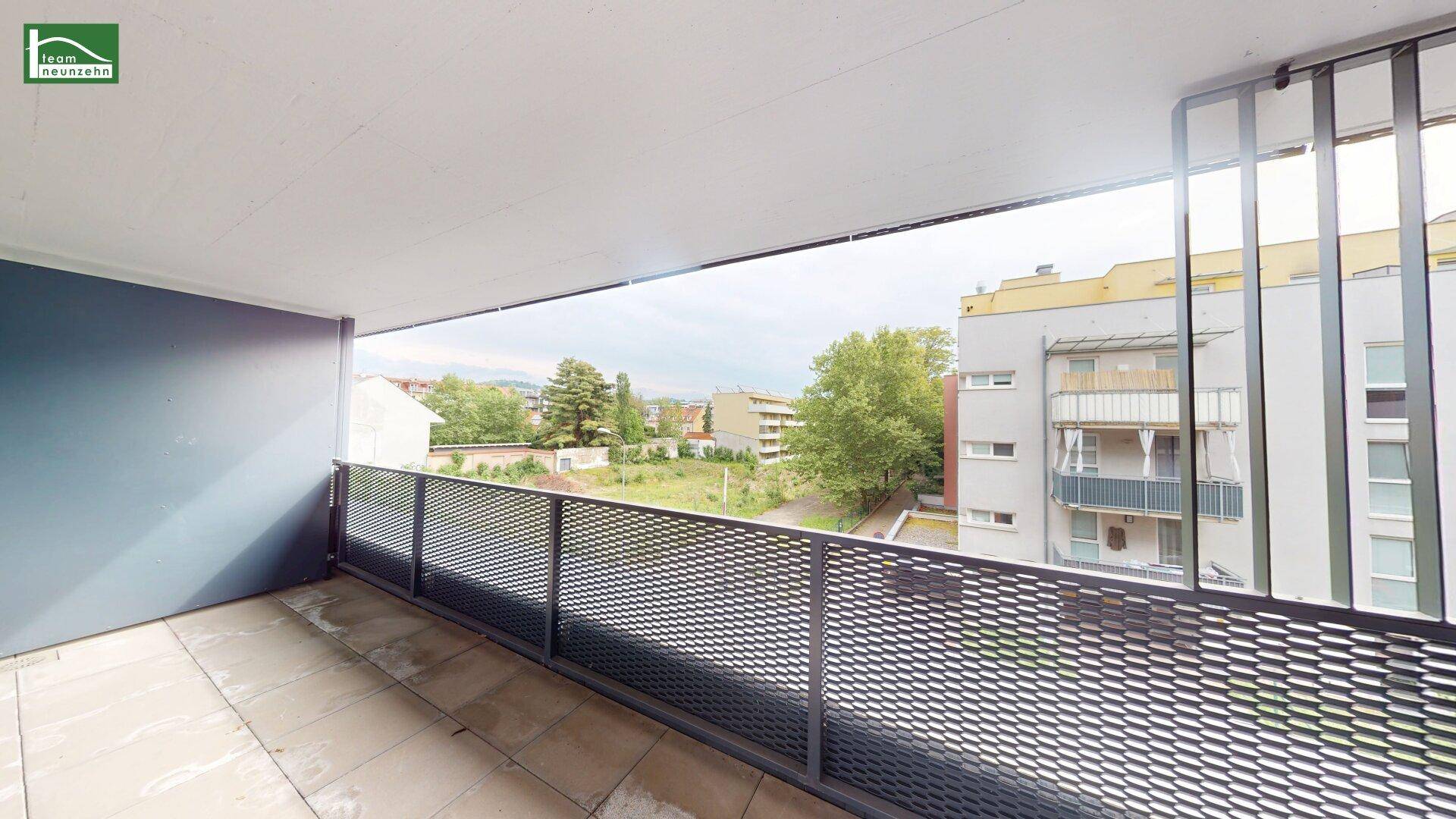 Geräumiger Balkon mit Fliesenboden und Metallgeländer, bietet Blick auf die Umgebung.