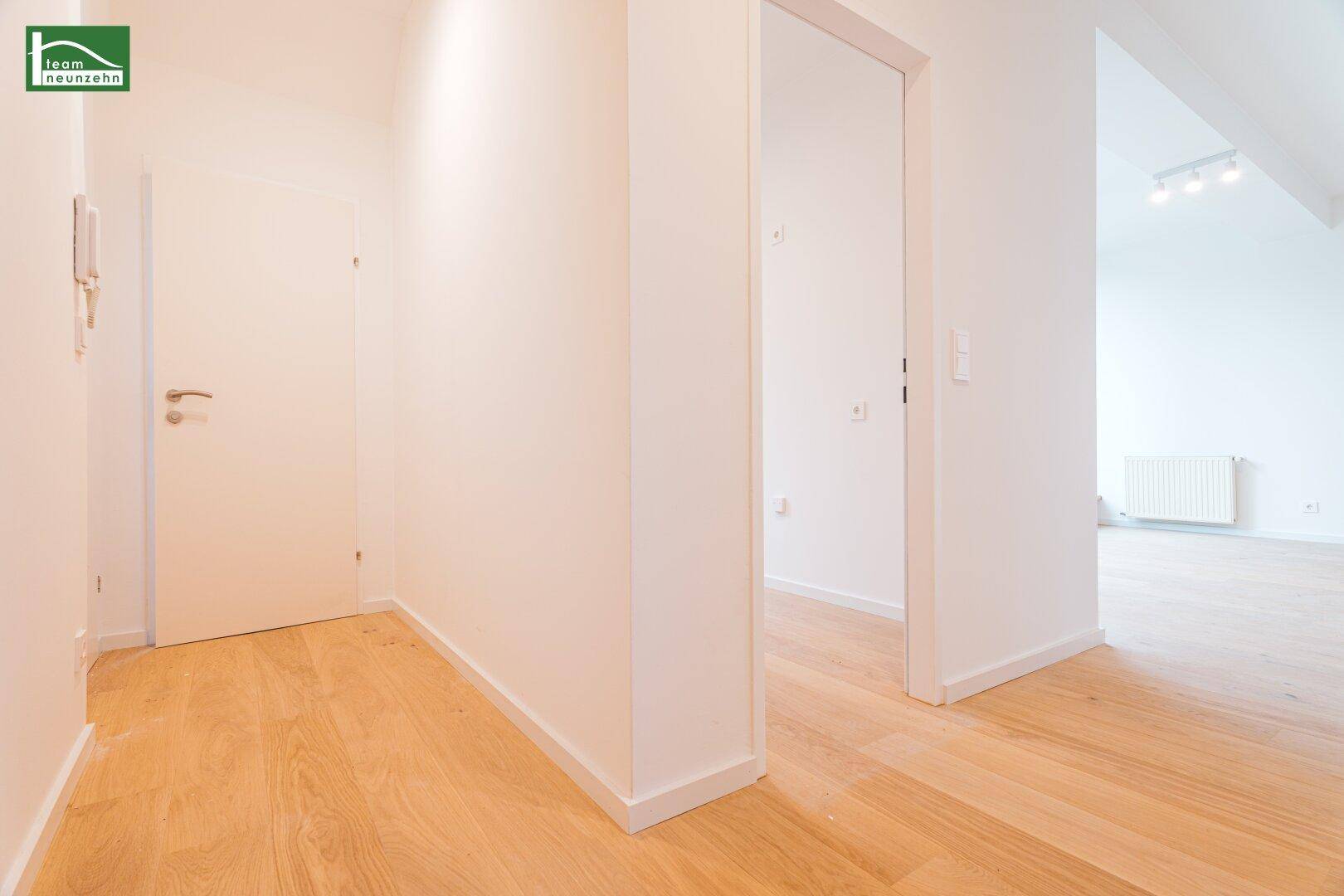Heller Flur mit Parkettboden, der zu weiteren Räumen der Wohnung führt.
