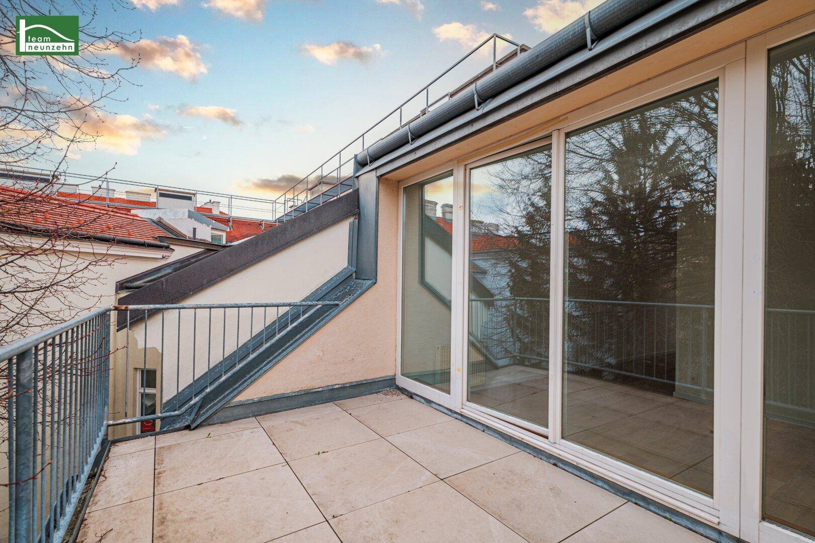 Heller Balkon mit Schiebetüren zum Innenbereich und Blick auf die Umgebung.