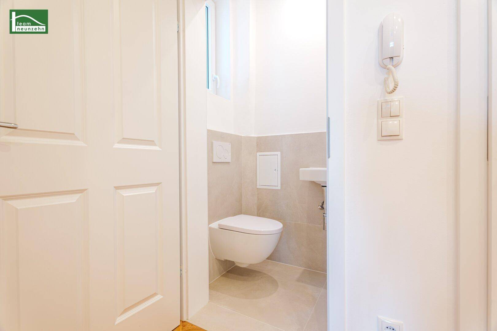 Kleines Gäste-WC mit wandhängender Toilette und kleinem Waschbecken.