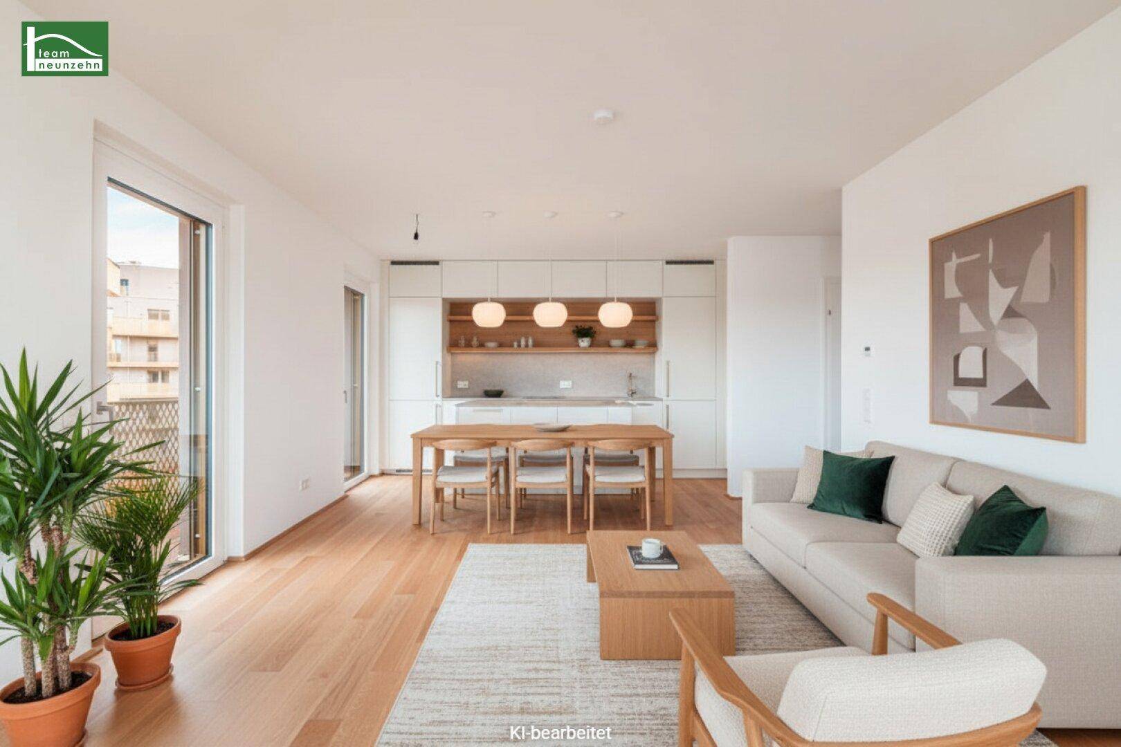 Heller offener Wohn- und Essbereich mit integrierter Küche, Holzboden und Zugang zum Balkon.