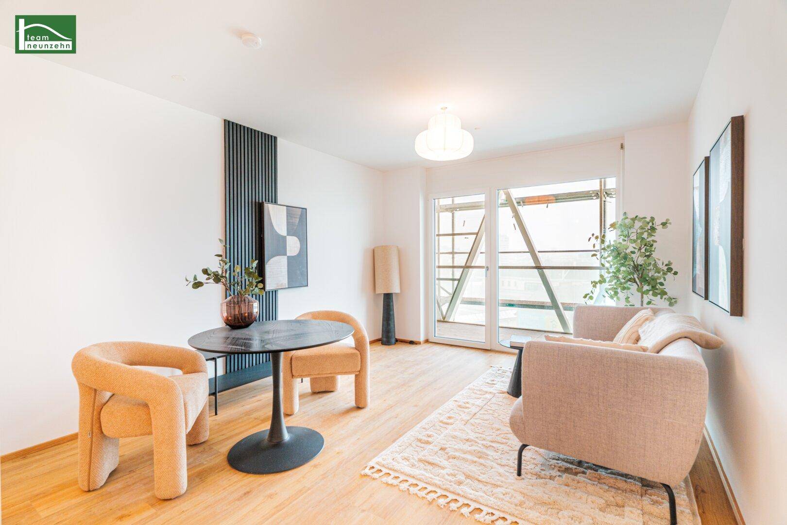Gemütlicher Wohnbereich mit Sofa, kleinem Tisch und Zugang zu einem Balkon.