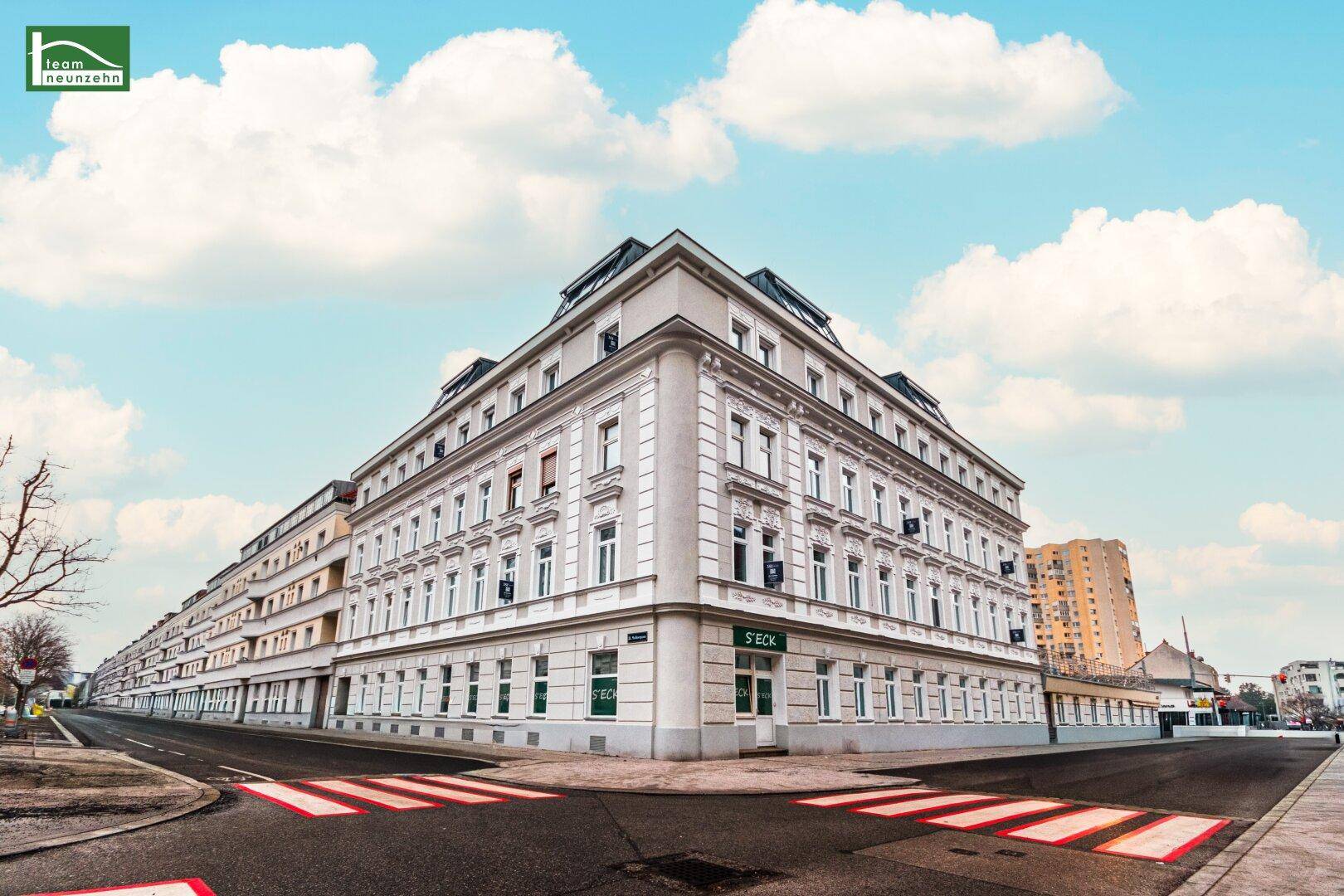 Eindrucksvolles Eckgebäude mit klassischer Architektur und vielen Fenstern in urbaner Umgebung.