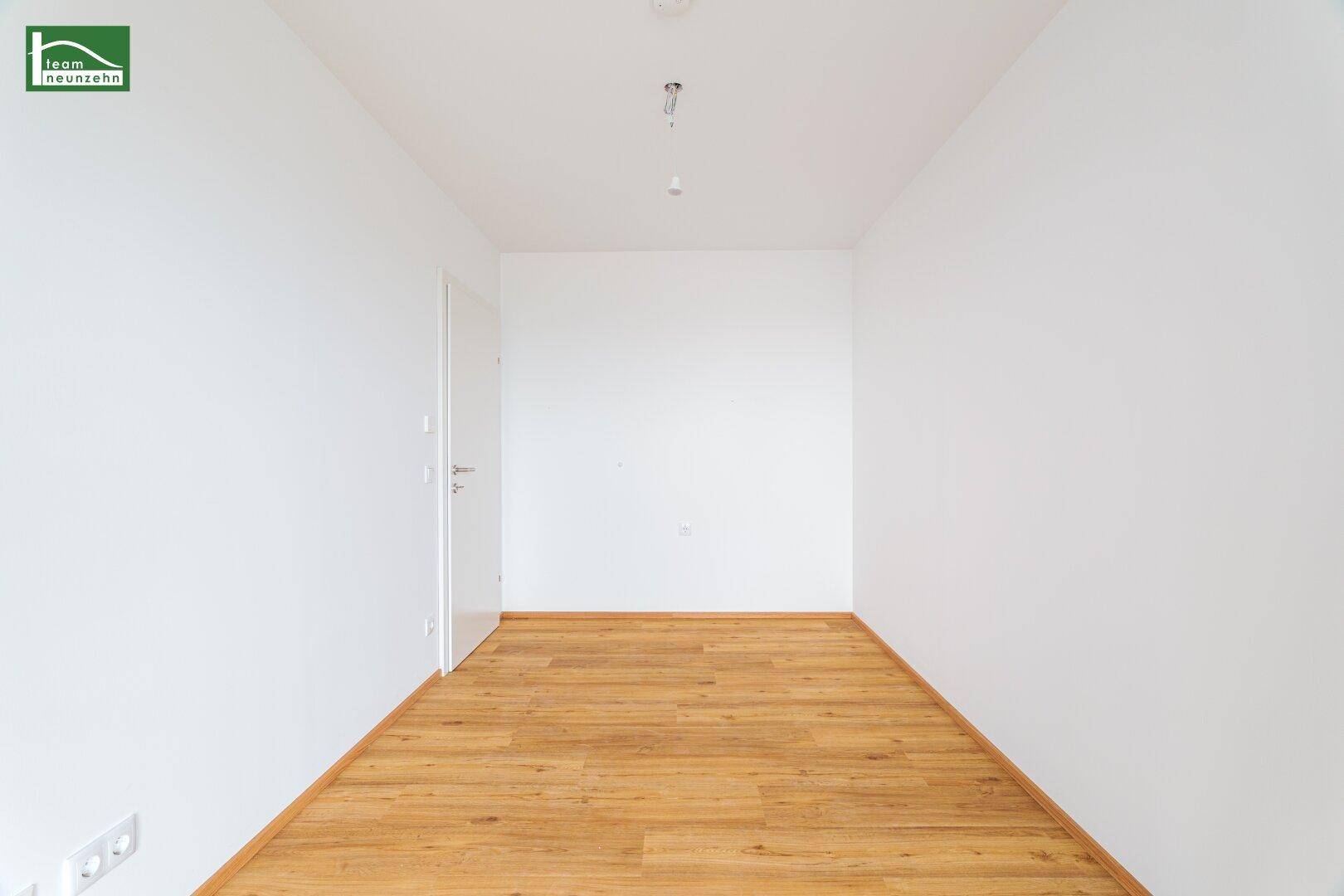Heller, leerer Raum mit Parkettboden und weiß gestrichenen Wänden, ideal für individuelle Nutzung.