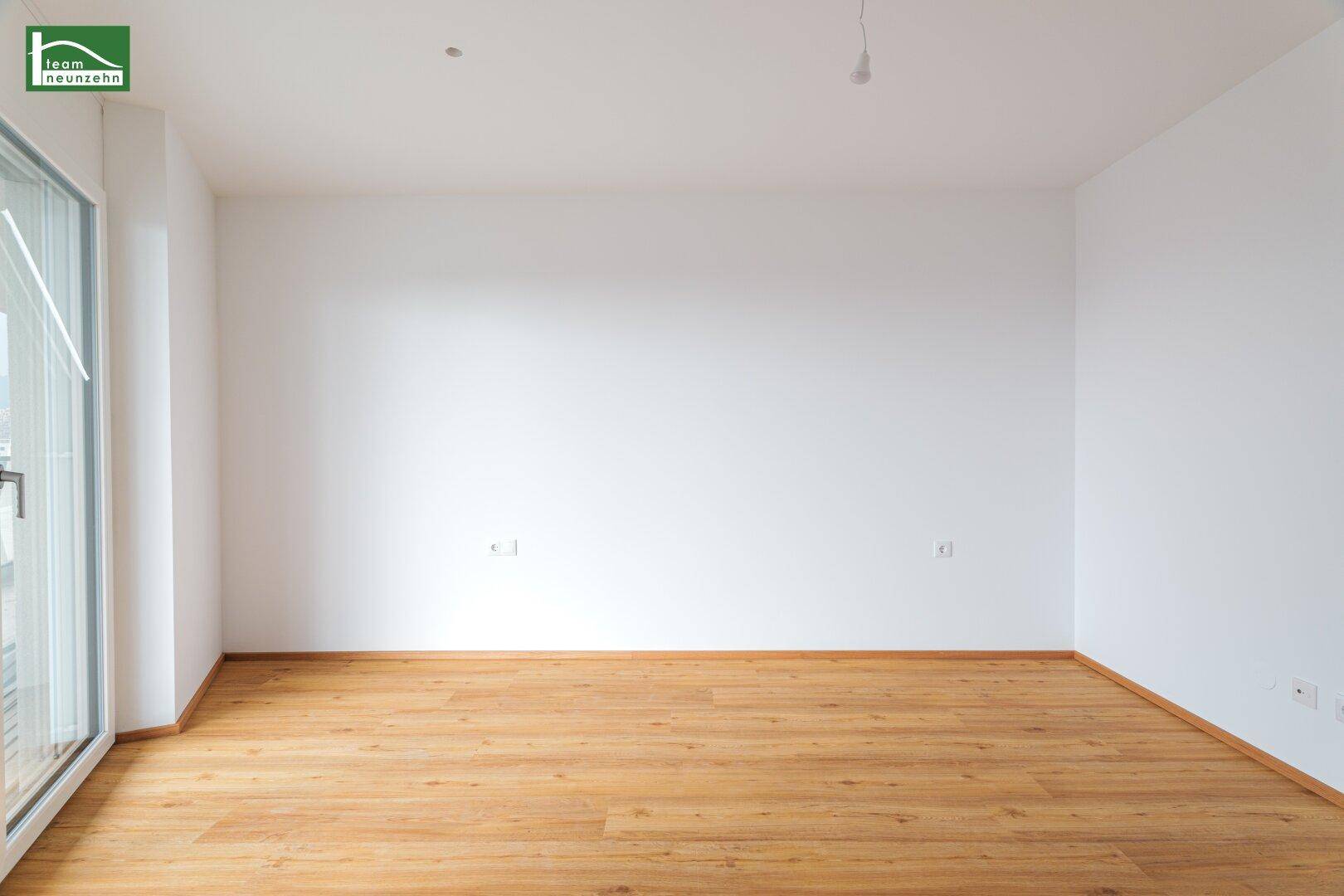 Leeres Zimmer mit großen Fenstern, die für viel natürliches Licht sorgen.