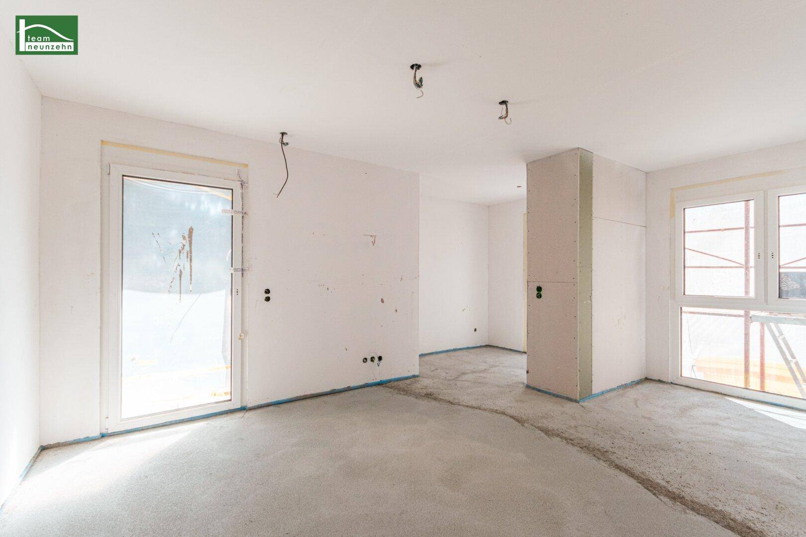 Heller Rohbau mit Betonboden und Zugang zu einem Außenbereich, ideal für die Gestaltung.