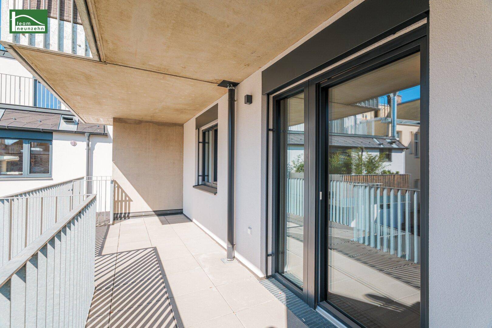 Langer Balkon mit Schiebetüren und Fliesenboden, ideal für entspannte Stunden im Freien.