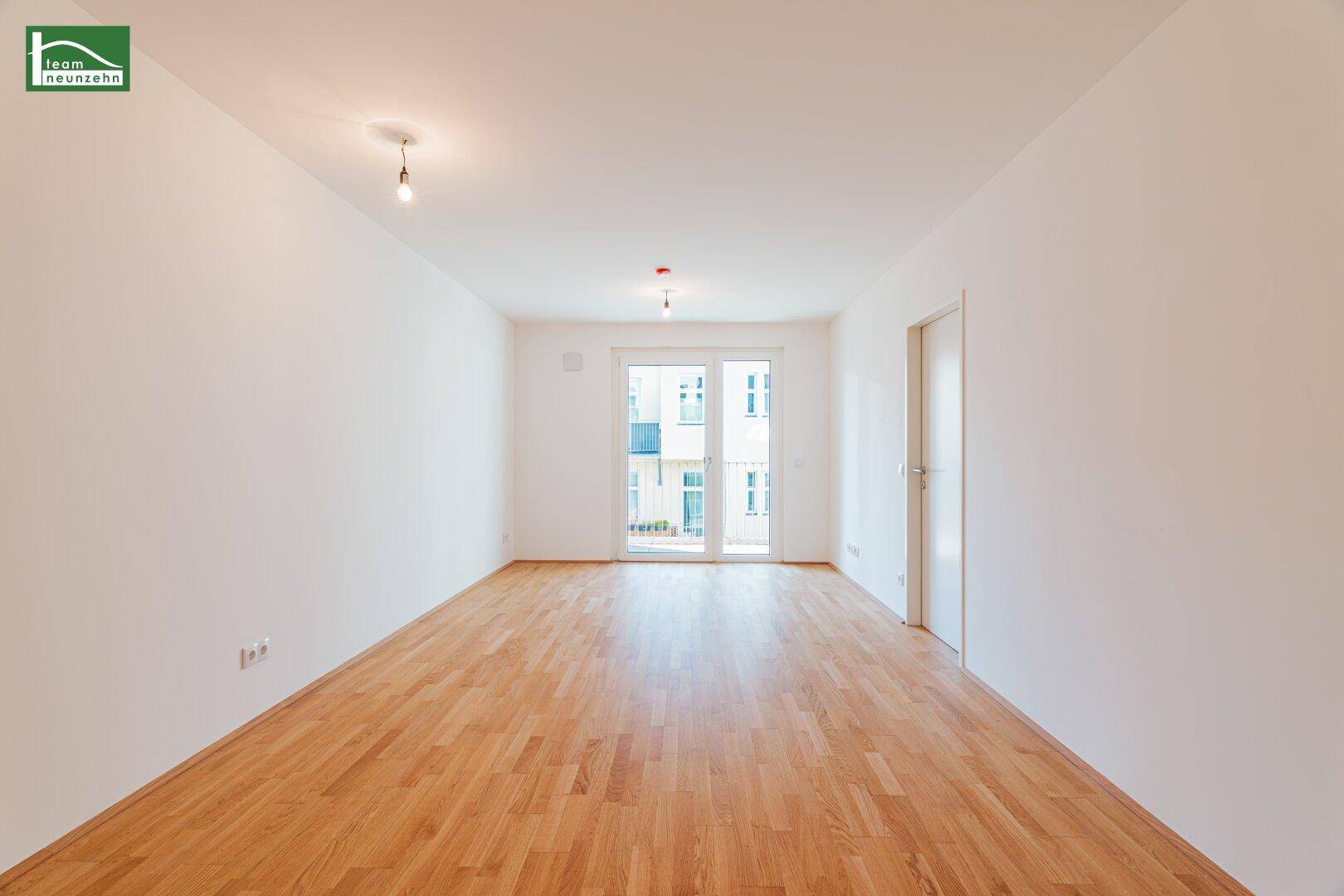 Geräumiges, helles Zimmer mit Parkettboden und Zugang zu einem sonnigen Balkon.