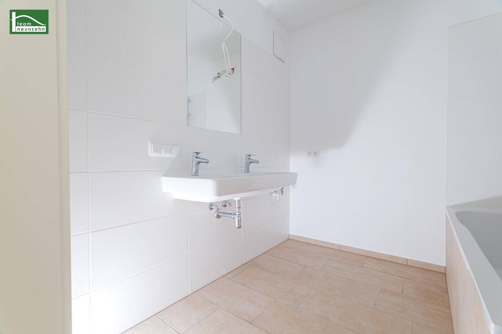 Modernes Badezimmer mit Doppelwaschbecken und hellen Fliesen, bereit zur Einrichtung.