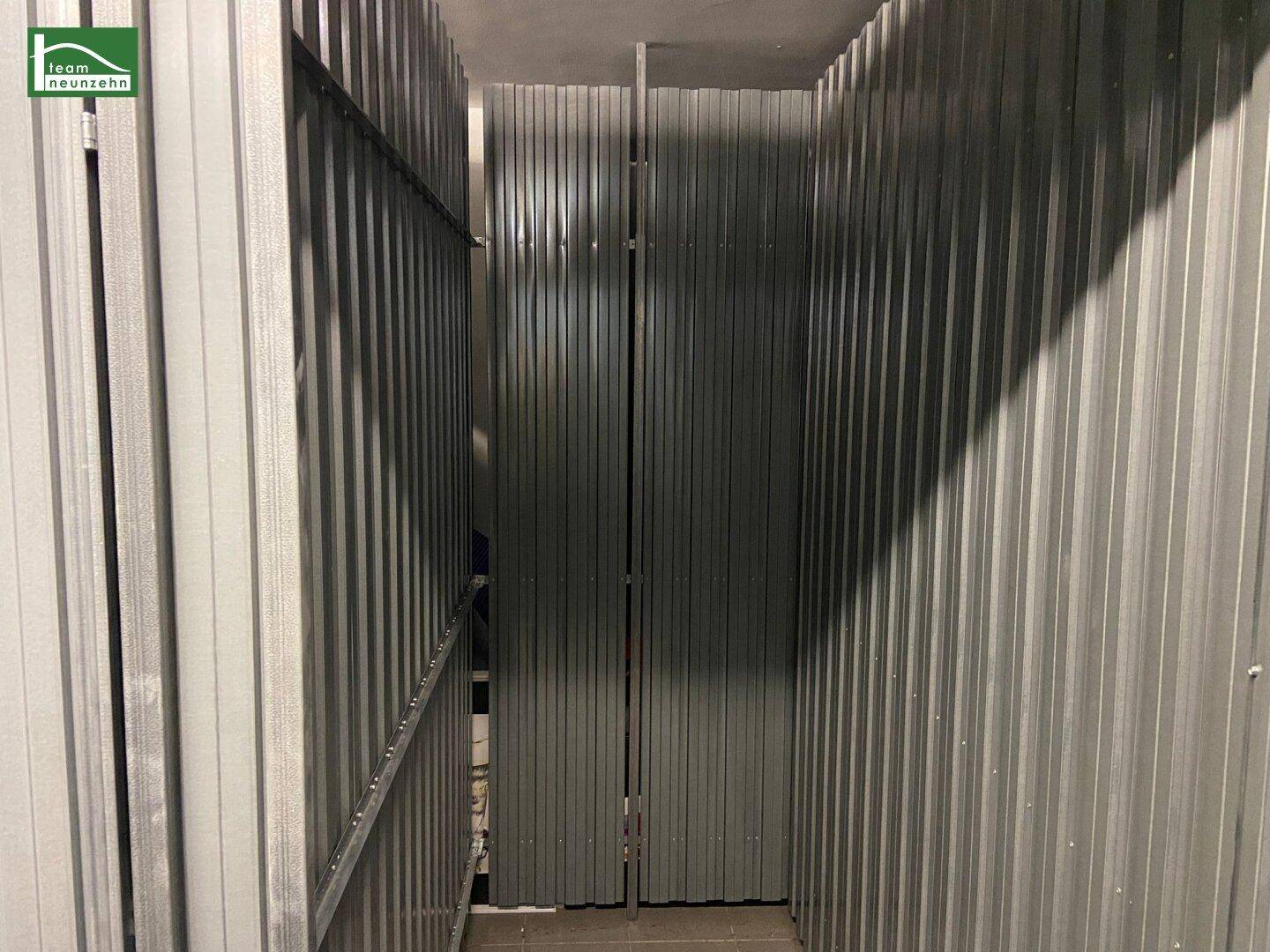 Schmaler Abstellraum mit Metallwänden, ideal zur Lagerung von Gegenständen.