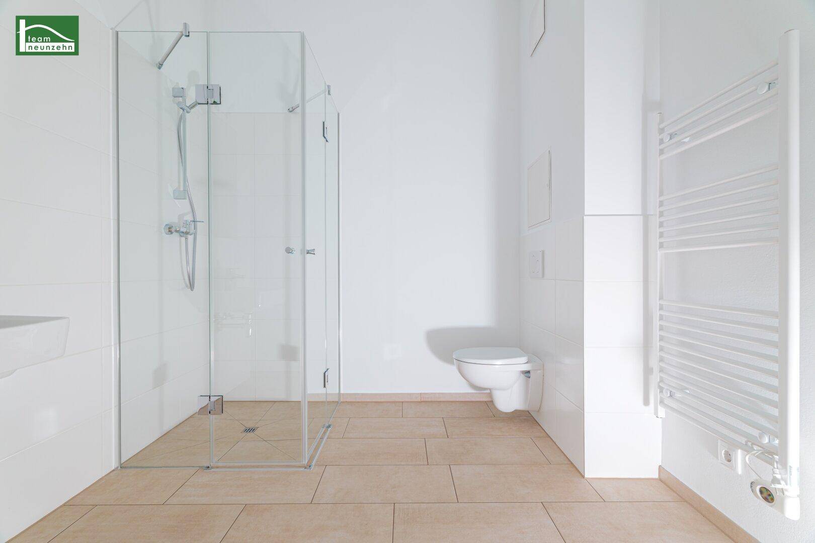 Modernes Badezimmer mit ebenerdiger Dusche, Wand-WC und Handtuchheizkörper.