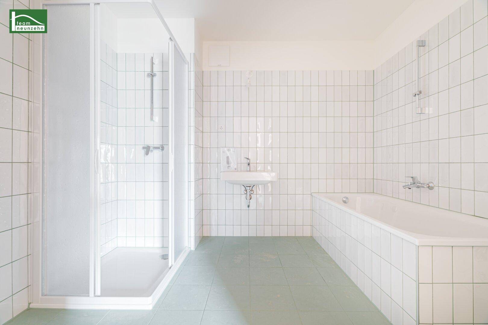 Funktionales Badezimmer mit weißen Fliesen, Duschkabine und Badewanne, in gutem Zustand.