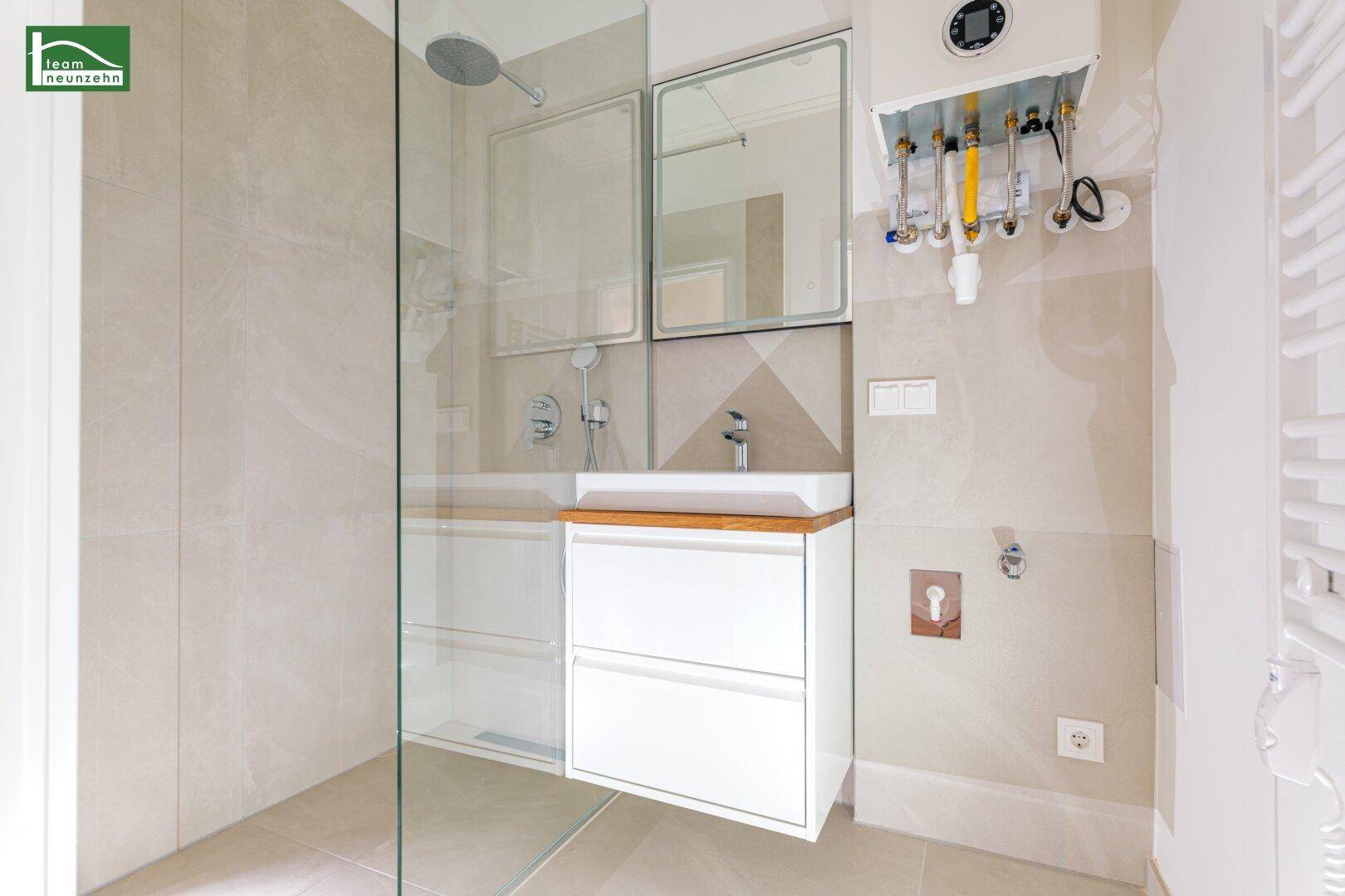 Modernes Badezimmer mit Dusche, Waschbecken und beheiztem Handtuchhalter.