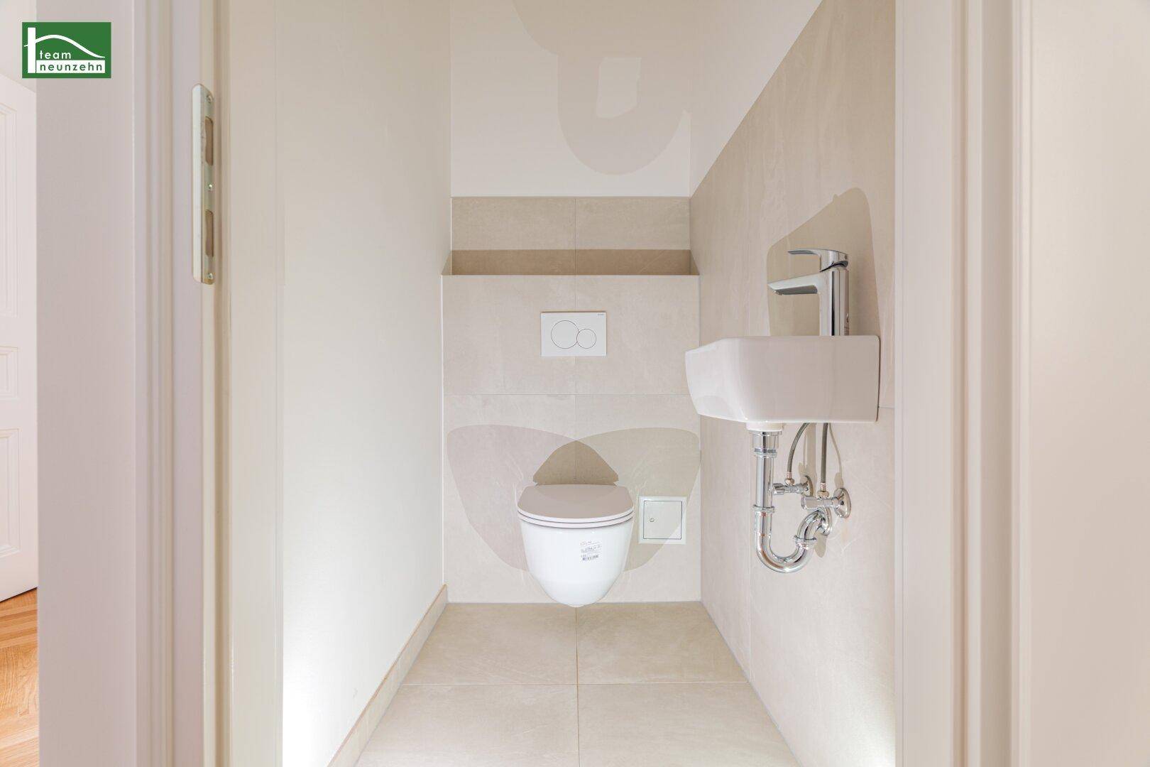 Kleines Gäste-WC mit wandhängender Toilette und modernem Waschbecken.