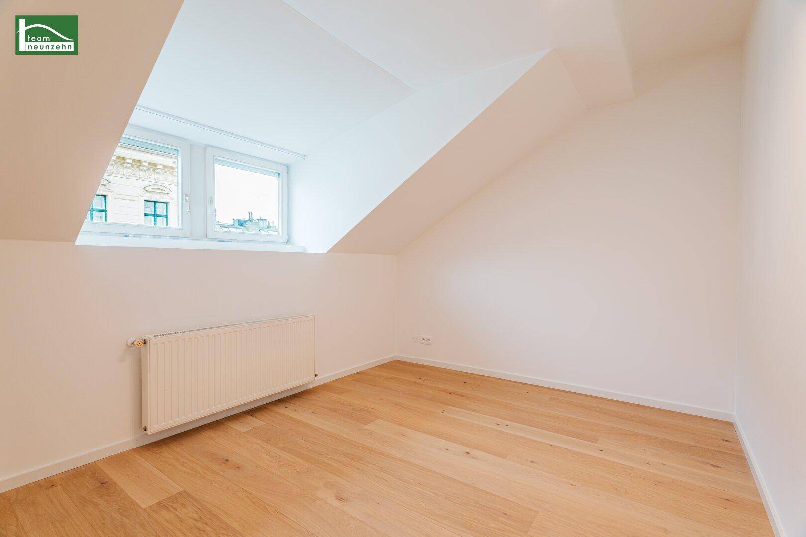 Geräumiges Schlafzimmer mit Parkettboden und schrägen Wänden im Dachgeschoss, ideal für Ruhe.