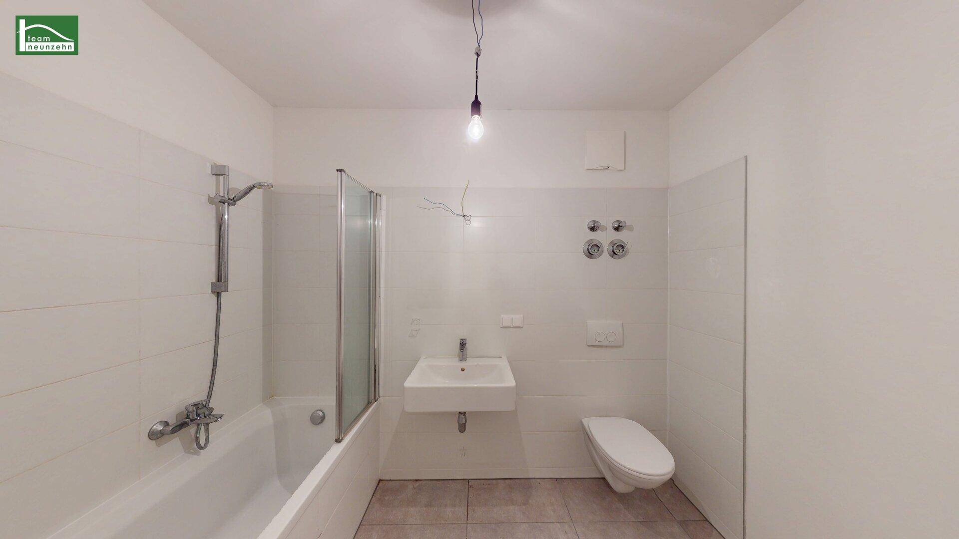 Modernes Badezimmer mit Badewanne, Duschabtrennung, Waschbecken und wandhängendem WC.