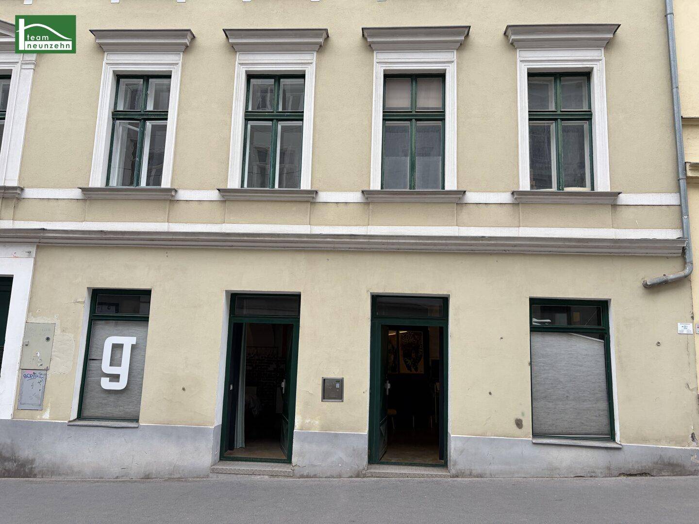 Erdgeschossfassade eines historischen Gebäudes mit Eingangstüren und Fenstern.