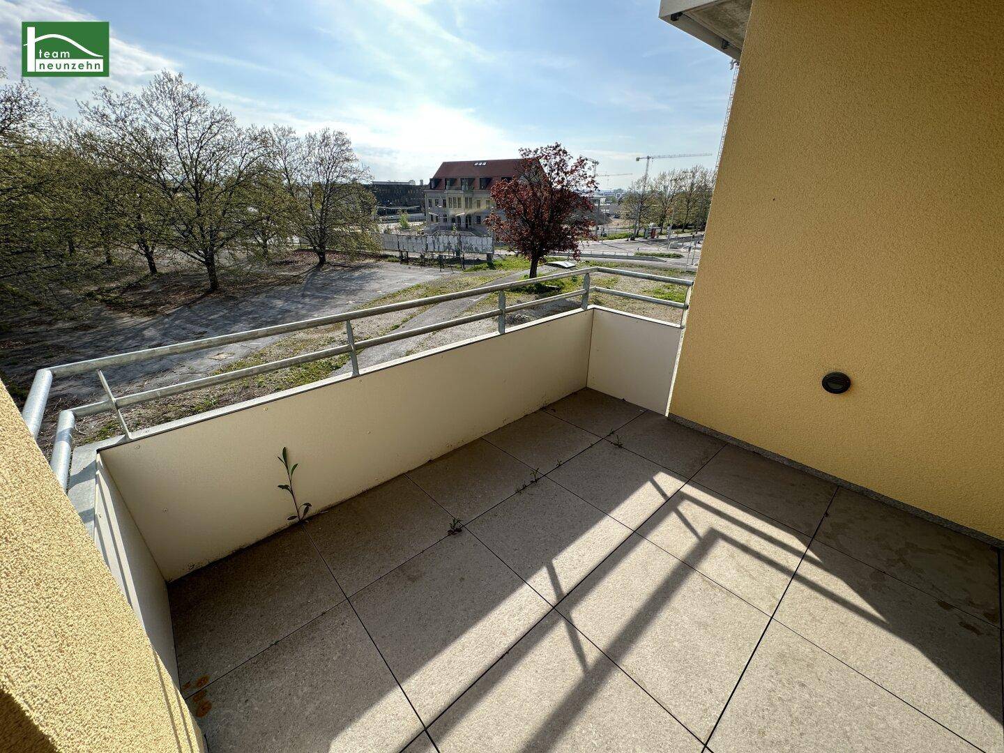 Geräumiger Balkon mit Fliesenboden und Blick auf die Umgebung, ideal für Entspannung.