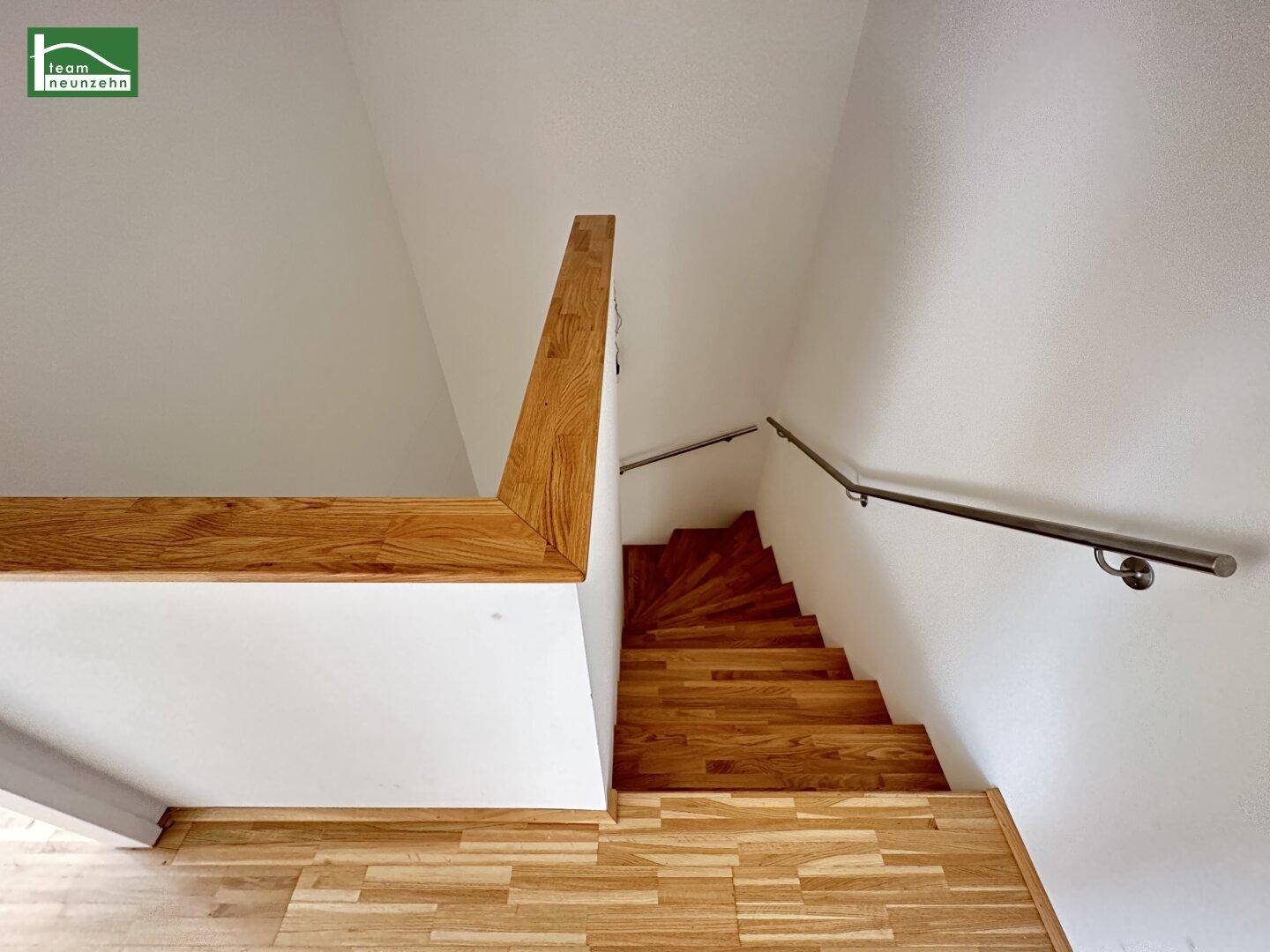 Treppenhaus mit Holzstufen und modernem Geländer, verbindet die Wohnebenen.